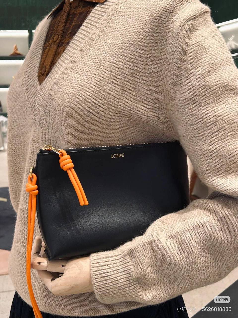 🎈𝘒𝘯𝘰𝘵 𝘛手拿包👜 —【黑色/耀眼橙到货✅】 编码：522414 尺寸：𝟐𝟐.𝟓-𝟓.𝟓-𝟏𝟓.𝟓𝐜𝐦 全新撞色绳结拉链头和腕带设计，顶部拉链开合，内部人字纹帆布衬里以及2个皮隔层卡位，正面饰以品牌标志性烫金𝗟𝗼𝗴𝗼，方便时尚多用。