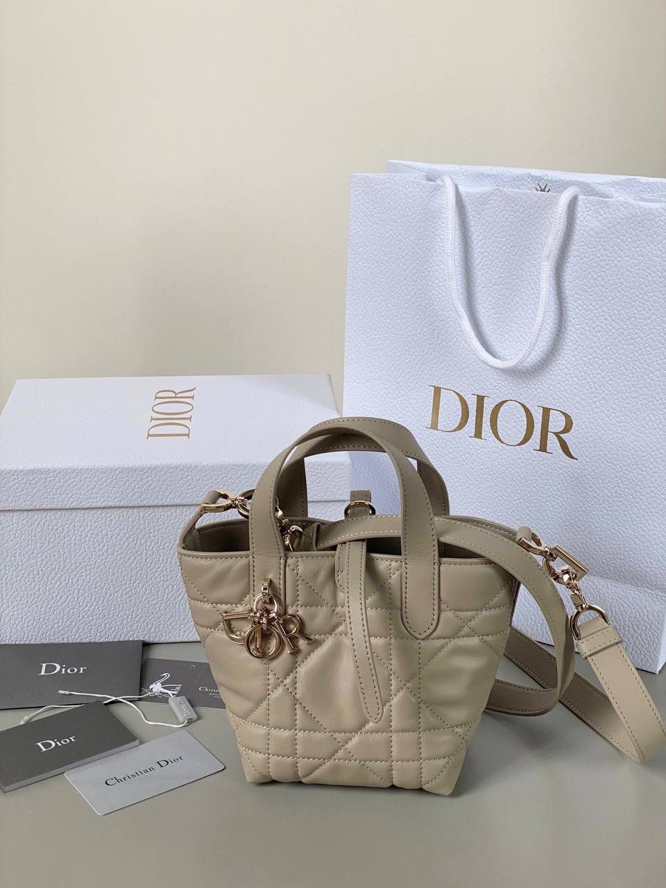 🈶胭脂米，迷你 𝗗𝗜𝗢𝗥 𝗧𝗼𝘂𝗷𝗼𝘂𝗿𝘀新版竖款 火爆全网toujours缩小版来啦！ 看到真的心动得不行～ 实物就是常规迷你水桶大小， 真的可爱死 别说，包虽小但容量还挺大的 日常用品都能轻松装上 肩带长度也刚刚好，不挑身高 反正就是太乖啦！夏日必备 😍 13×15×12cm #M1272m