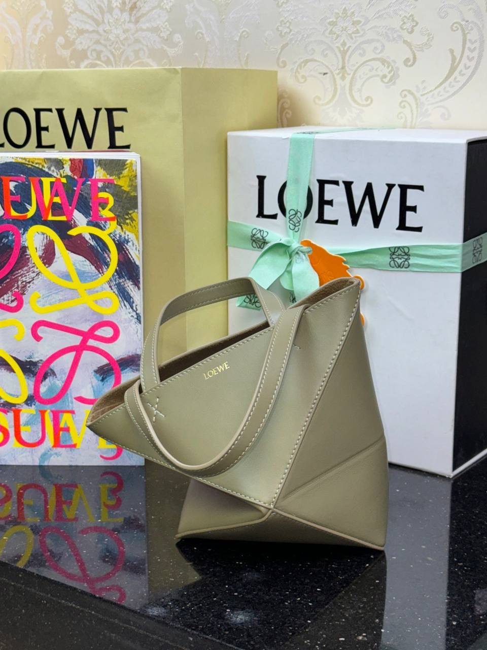 *𝐏𝐮𝐳𝐳𝐥𝐞 𝐅𝐨𝐥𝐝折叠手袋👜* ——全新【𝗡𝗘𝗪】升级‼️ 延续经典𝙋𝙪𝙯𝙯𝙡𝙚的标志性几何裁剪设计，新晋顶流🅰️𝙋𝙪𝙯𝙯𝙡𝙚 𝙁𝙤𝙡𝙚 𝙏𝙤𝙩𝙚以折纸包为灵感，升级成🉑完全折叠‼️的结构，立体与平面任意切换，出差旅行🧳必备单品。小牛皮材质轻且柔软，𝐌𝐢𝐧𝐢尺寸搭配一条可拆卸式肩带，手提，肩背，斜挎多样化背法✨ 尺寸：𝟏𝟔.𝟓-𝟗.𝟓-𝟐𝟎cm 款号：052322