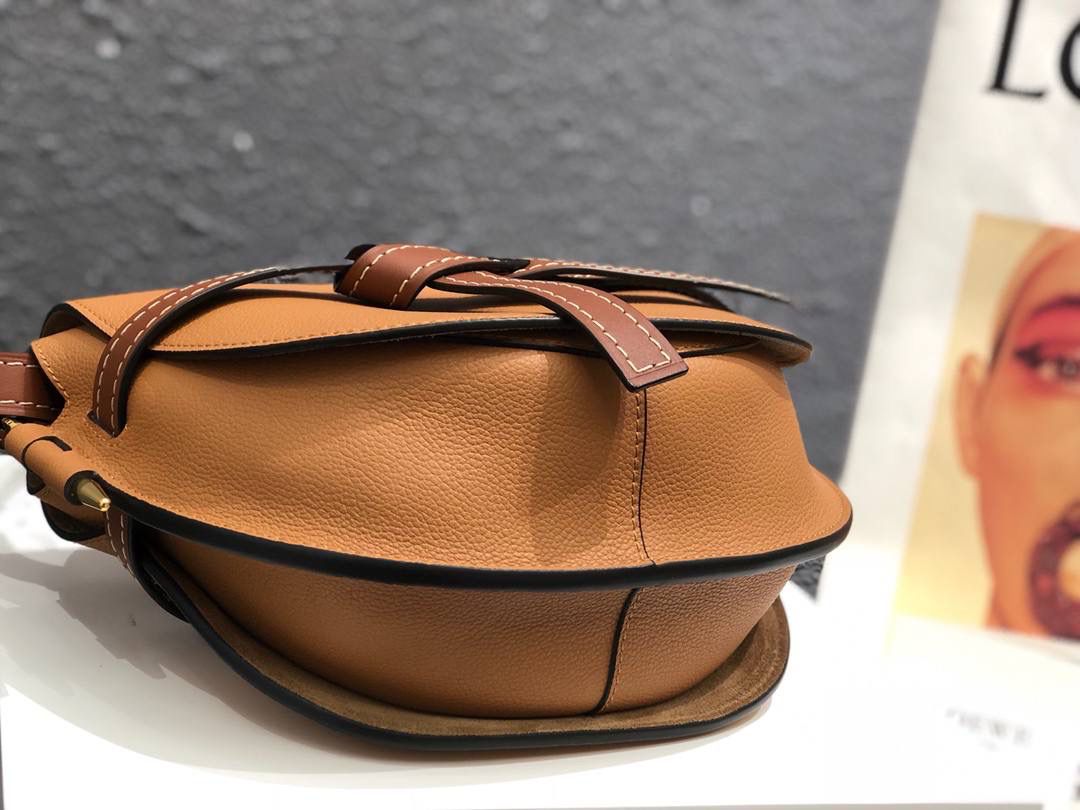 Loe❤️we专柜官网主推最新颗粒纹GATE BAG 👜蝴蝶结🎀不仅是装饰，也是包盖的唯一插口。全包只有一个带品牌精致logo 的子弹头式黄铜插鞘，没有其他五金配件，完全是高大上的西欧传统皮革工艺性和设计风格，So 自重轻便，肩带🉑️调节长度，任何身高妹纸都可驾驭，这点很nice了💃💃 👜小号尺寸:20*19*11.5cm,包身是非常柔韧的颗粒纹小牛皮，内部是麂皮，两个隔层，有一个卡袋，装得了短钱夹，手机，口红💄，气垫等，容量非常感人😇假如想带个kindel 也还是可以的哟😍😍 👜林允儿同款焦糖色，再撞个经典红棕色，包包马上upgrade ⬆️个几阶[得意]，高大上的气质感[色][色]，一眼就种草[色][色] 👜zp拆包定制，高端独家私定制五金，小牛皮，德国进口纱菲线，zp工艺，让你尊享顶级品质！ 型号:061711棕荔枝