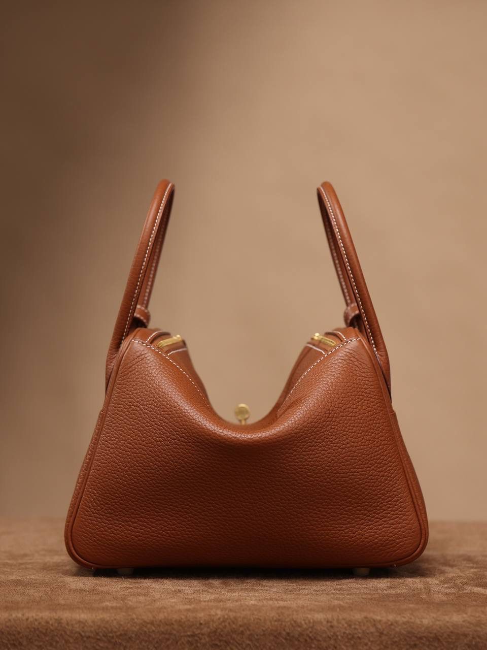 Hermes 爱马仕 Lindy 26cm 金棕金扣👜✨ Lindy 独家渠道货 独家欧洲原厂皮原厂五金组装的ZP尾单货 尺寸：26*18*14 cm Lindy是采用原厂的正品TC皮，什么是TC皮？ 爱马仕专用的clemence,简称tc皮，是Hermes最受欢迎的皮革之一，颜色会比Togo少一些，但是纹路比Togo细腻，含油更高，更软，因此稍稍有些下垂感的特点。 欣赏独家货源的美 闭眼入😍🤭🤟🏻