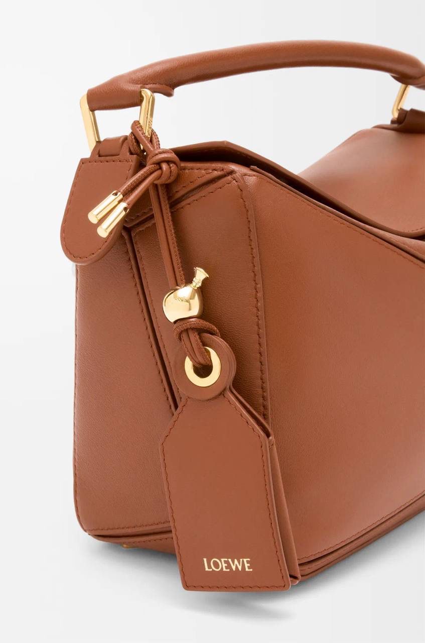 【十周年限定款🆚经典款】 👉🏻区别1️⃣：里外全羊皮，侧面增加可拆卸标牌挂饰以及气球骰子，内里更换为金标（如图1️⃣2️⃣3️⃣4️⃣） 👉🏻区别2️⃣：底部增加脚钉保护整个包包，以前只有中号以上才有（如图5️⃣） 👉🏻区别3️⃣：铰链式拉链头，拉牌刻有品牌创建年份以及品牌英文LOGO（如图6️⃣7️⃣） 👉🏻区别4️⃣：肩带调节变更为针扣调节（如图8️⃣）