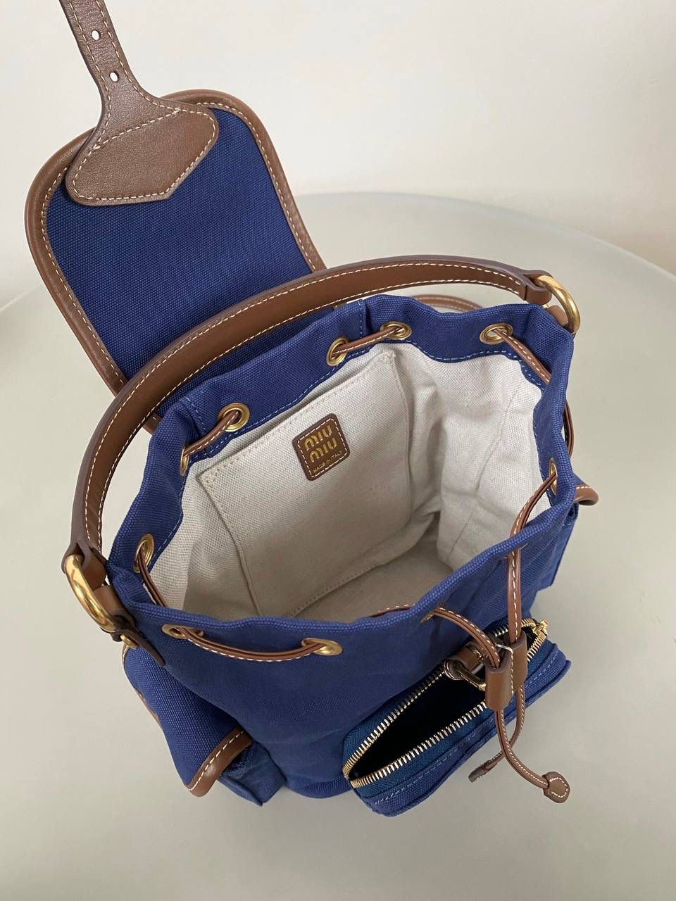 🈶帆布蓝，小号 𝐌𝐢𝐮𝐌𝐢𝐮 双肩包 喔噻！缪缪终于出双肩包了！ 超级经典的款，配色也是无敌了 多个口袋设计非常复古学院风，青春洋溢！ 五金质感超绝，带有微微做旧的复古磨砂感 这种材质耐用度极高 帆布版俩个颜色都好看！海军蓝，甜酷不失高级感 总的来说夏天就是要拿个亮色的出游 轻便实用 小号：18×22×11.5cm #F0060m 大号：25x29x12.5cm