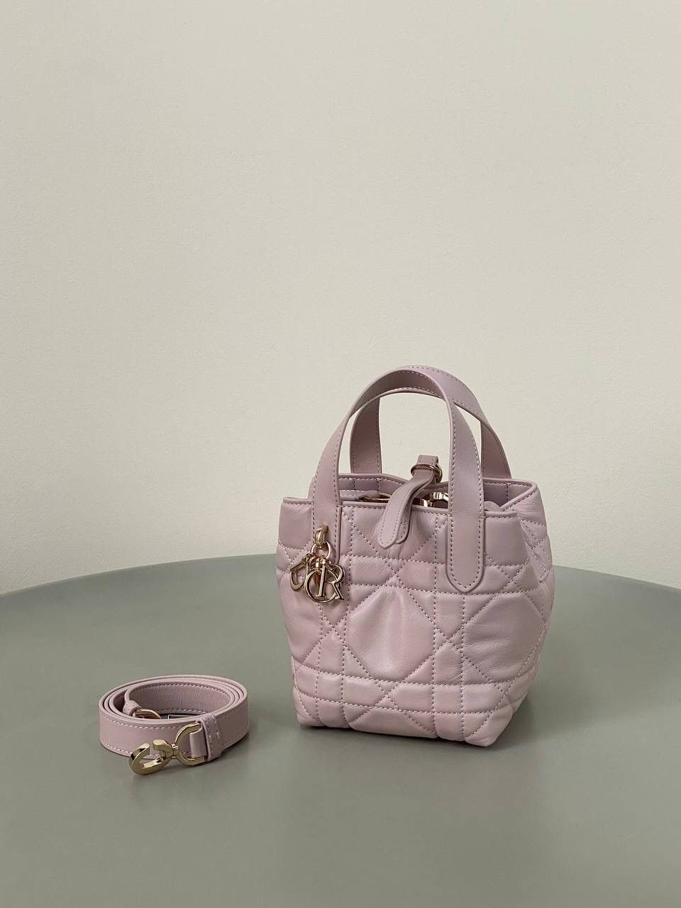 🈶粉色，迷你 𝗗𝗜𝗢𝗥 𝗧𝗼𝘂𝗷𝗼𝘂𝗿𝘀新版竖款 火爆全网toujours缩小版来啦！ 看到真的心动得不行～ 实物就是常规迷你水桶大小， 真的可爱死 别说，包虽小但容量还挺大的 日常用品都能轻松装上 肩带长度也刚刚好，不挑身高 反正就是太乖啦！夏日必备 😍 13×15×12cm #M1272m