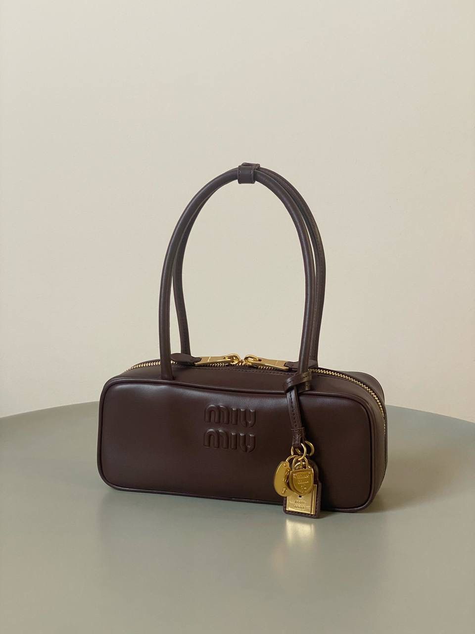 🈶石南木色 𝗠𝗶𝘂𝗠𝗶𝘂保龄球| 吊饰版 说是公文包.更是保龄球！ 虽倆者都早已大火全网时髦圈哈哈 今年这只长手柄保龄球能买到就是赚到咯！ 细长的手柄整体更秀气了 还送了一串吊饰 是一把锁头还有一个爱心， 上面都有logo刻印很精致也很厚重 宝子们再也不愁买挂饰啦！ 28×11.5×8cm #F0010m