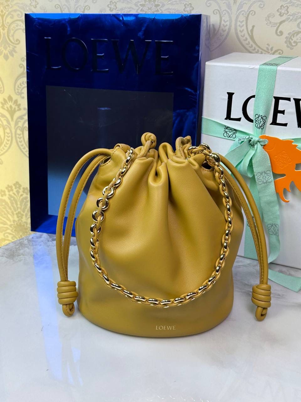 🎈链条款𝙁𝙡𝙖𝙢𝙚𝙣𝙘𝙤 𝙋𝙪𝙧𝙨𝙚水桶羊皮 ——【沙漠黄】 尺寸：𝟑𝟐-𝟏𝟕-𝟐𝟒𝐜𝐦 编码：062406 👉🏻延续福袋收缩绳褶皱设计，全新推出水桶造型，羊皮包身手感细腻柔软❤️ 👉🏻链条肩带➕皮肩带的双肩带设计，时尚百搭，给足了集美们多样化的选择。肩带可拆卸可调节，磁扣开合，正面烫金𝙇𝙤𝙜𝙤，呈现出高贵典雅的视觉感😍 👉🏻独家背景➕独家品质➕独家全套砖柜礼盒套装，市场高端品质皆在我手✌🏻