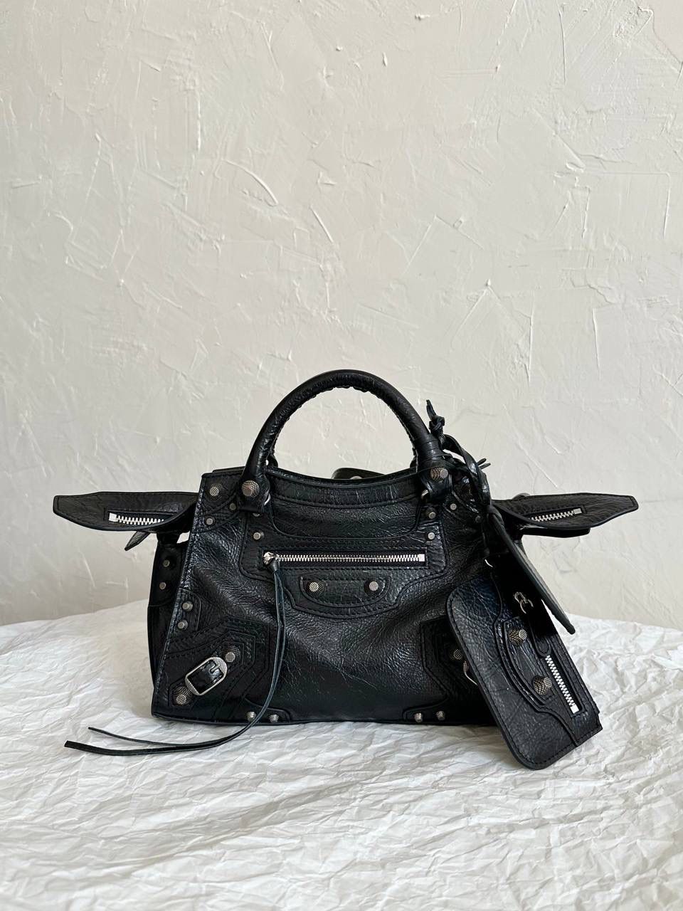 ba1enciaga Neo classic 机车包xs 黑银🖤 首先声明，我爱一切机车元素 无论是le cagole还是这只neo 喜欢大容量的姐妹冲这只 油蜡皮的不规则摔纹配上大量的五金配件 还有流苏拉牌➕爱心镜子➕零钱包挂件 极繁的魅力由此而来～ 辣妹酷妹冲冲！ 26×17.8×11.4cm700940m