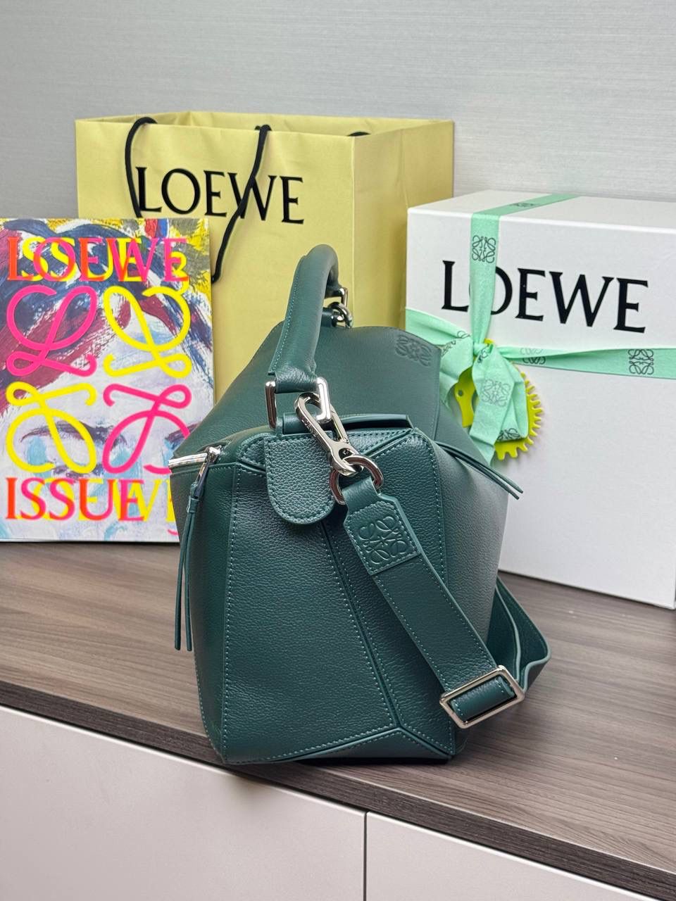 🎈【全钢】大号鹿皮𝘗𝘶𝘻𝘻𝘭𝘦* ——【👉🏻常青色到货✅】 尺寸：𝟑𝟐.𝟓-𝟏𝟒.𝟓-𝟐𝟑.𝟓𝐜𝐦 编码：260403 【配全套包装】 ❤️经典拼图系列•不规则立体几何设计•最具辨识度的立体廓形和几何美学•顶级进口皮搭配德国沙菲线•独家定制五金•𝗬𝗞𝗞拉链拉头。 ❤️该款大号采用鹿皮革制成•绒面内里•搭配一条可拆卸可调节的皮肩带•肩背斜挎或手提多样化背法。