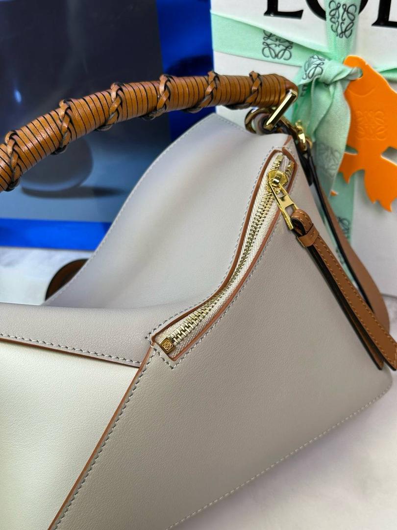 🎈最新编织手腕𝙋𝙪𝙯𝙯𝙡𝙚 ——【灰兰拼色】 尺寸：𝟐𝟒-𝟏𝟎.𝟓-𝟏𝟔.𝟓𝐜𝐦 编码：062405 ♥️以罗家经典几何设计，搭配独特的编织手腕，人字纹里布。 ♥️容量大，经典百搭，可拆卸肩带，有单肩，斜挎，手提等多样化背法。随性时髦洒脱，实用性强。 ♥️独家背景➕独家品质➕独家全套砖柜礼盒套装，市场高端品质皆在我手✌🏻