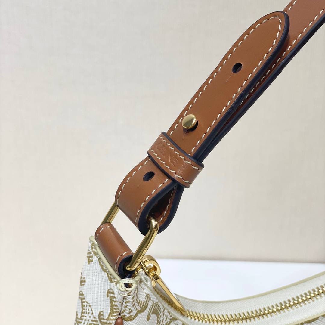 🔥大货实拍图 𝗖𝗘𝗟𝗜𝗡𝗘 ♥ 𝗧𝗥𝗜𝗢𝗠𝗣𝗛𝗘 𝗖𝗔𝗡𝗩𝗔𝗦 𝗔𝗩𝗔 灵感来自1990年代中古包Macadam，采用小巧优雅的月牙形轮廓，搭配耐看的棕色调凯旋门老花和小牛皮滚边，透出复古娇俏气质。型号：193952 尺寸：23*14*7cm