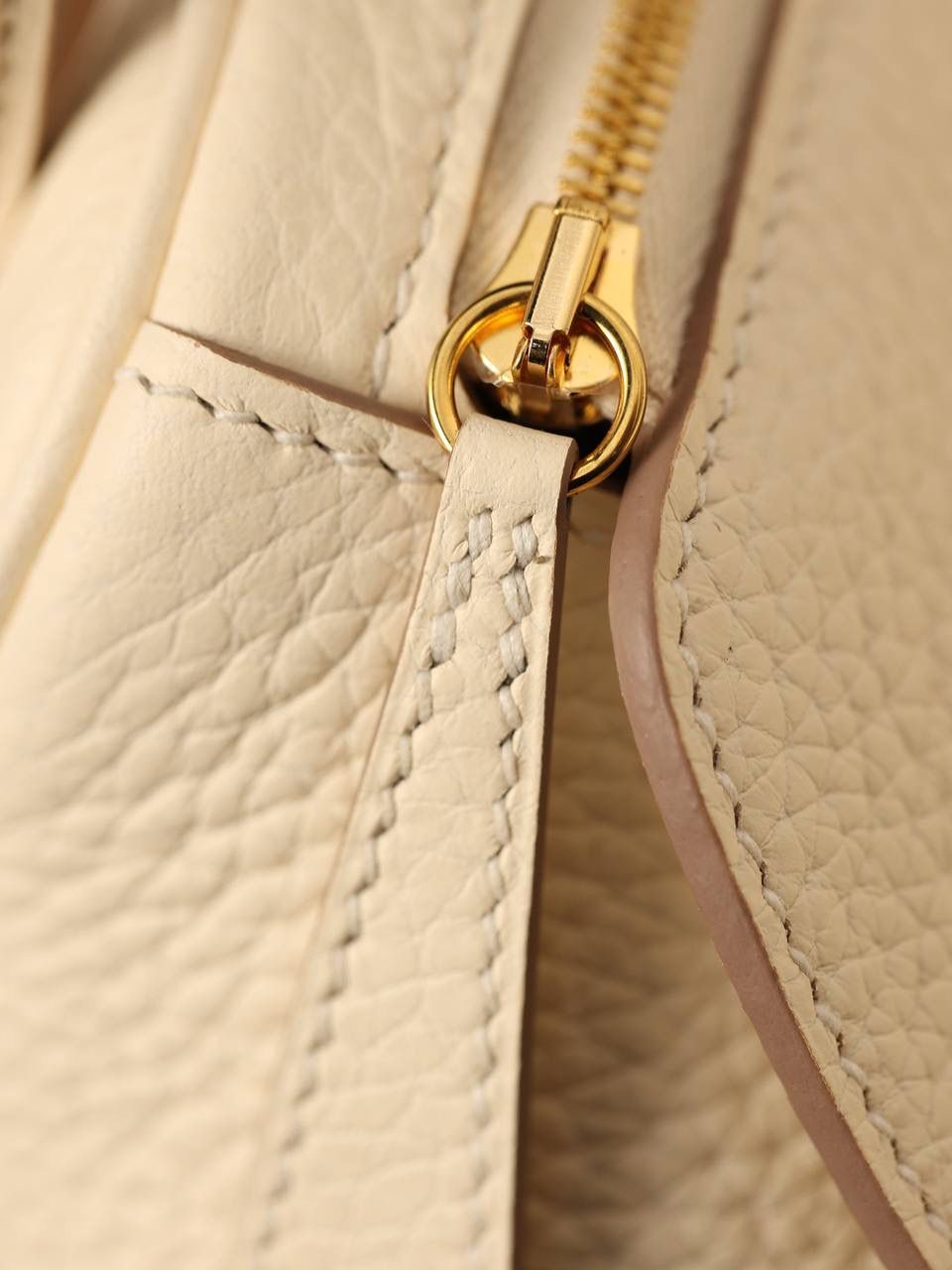 Hermes 爱马仕 Lindy 26cm 奶油白金扣👜✨ 尺寸：26*18*14 cm 奶油白真的实物很漂亮，YYDS😍 五金介绍，拉链尾部的"H"是刚好的正方形，而且每笔都是很直，菱角分明，表明平整 图二至六图的的五金四个小螺丝是人工围着这四个小圆点边雕琢上去的，而且小螺丝这点的周围圈是有孤独深的圆形，这点很多人都不知道，这个是符合正品工艺的 拉链是纯原装金扣的RIRI拉链 所以在五金方面我们拿捏的死死的 无人能敌 🤟🏻 渠道货是注重任何一个细节的 做到任何人都做不到的点 这就是天花板😍💯👍