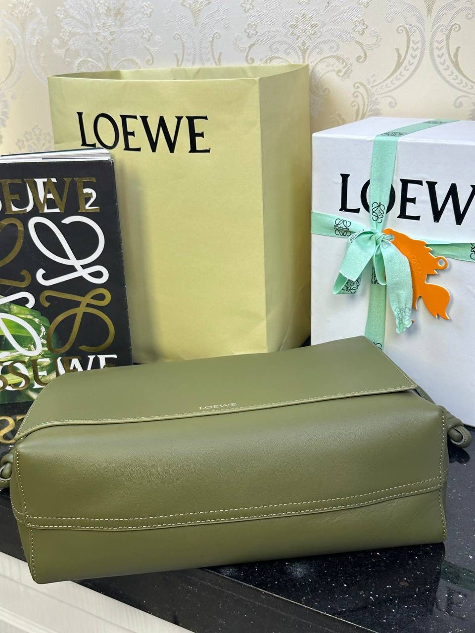 【全皮橄榄色】 𝙇𝙤𝙚𝙬𝙚 𝙁𝙡𝙖𝙢𝙚𝙣𝙘𝙤 𝙎𝙖𝙩𝙘𝙝𝙚𝙡 福袋款邮差包 ➕刺绣🅾️字母宽肩带 编码：062404 尺寸：𝟑𝟒-𝟏𝟐-𝟐𝟒𝐜𝐦 新款以经典福袋收缩打结为元素，采用内部麂皮➕外部进口小牛皮➕刺绣字母宽肩带的精致搭配打造全新升级款邮差包🅰️，可斜挎、肩背和手提，超大容量满足日常所需🎈