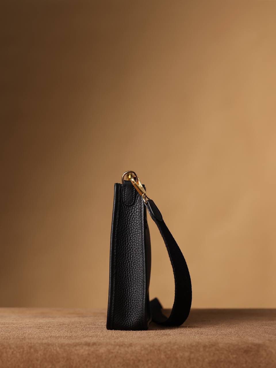 HERMES爱马仕Evelyne 16伊芙琳黑色金扣👜✨ TaurillonMaurice 小公牛皮 尺寸：16*18*5cm 爱马仕Evelyne伊芙琳 Evelyne包的设计灵感来自于一种名为“马鞍袋”的马具袋，这是一种常用于骑手和马车夫的袋子，用于储存和运输马具和其他必需品。 爱马仕将这种马具袋的经典元素与品牌的手工艺传统相结合，打造出了具有时尚感和功能性的包包。 因此，伊芙琳包不仅是一款实用的手提包，同时也代表着品牌深厚的历史和文化传统❤️