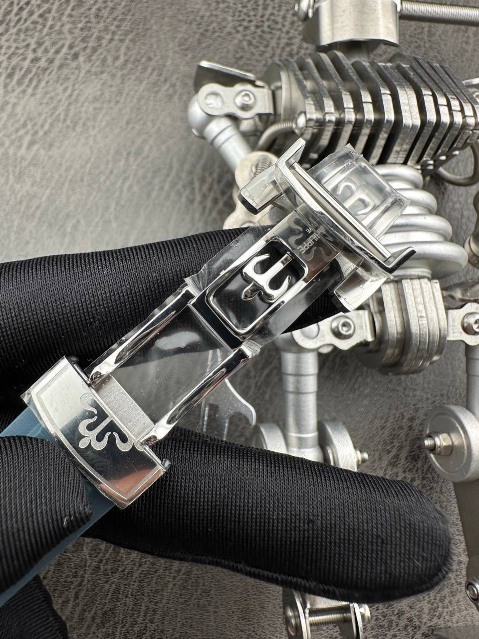 百达翡丽Aquanaut系列😎 【表壳】40.8MM表径，不锈钢材质，圆润的八角壳型恰到好处，表壳左侧的鲨鱼鳍型设计，是可以前后快调中央镂空时针的按钮，这枚指针可以用来指示第二时区时间。 【表盘】黑色浮雕表盘，金属立体字块，覆荧光涂层时标。3、9点钟分别显示”HOME”与”LOCAL”的方形昼夜视窗，蓝白二色各自代表晚上与白天，6点钟位置是指针式的日期盘。 【机芯】成功实现百达翡丽5164A-001内载的324 SC FUS自动上链机芯功能，大三针基础机芯上搭载两地时间模组。 配有休闲气息的Tropical表带，正是为年轻世代所准备的奢华运动表。