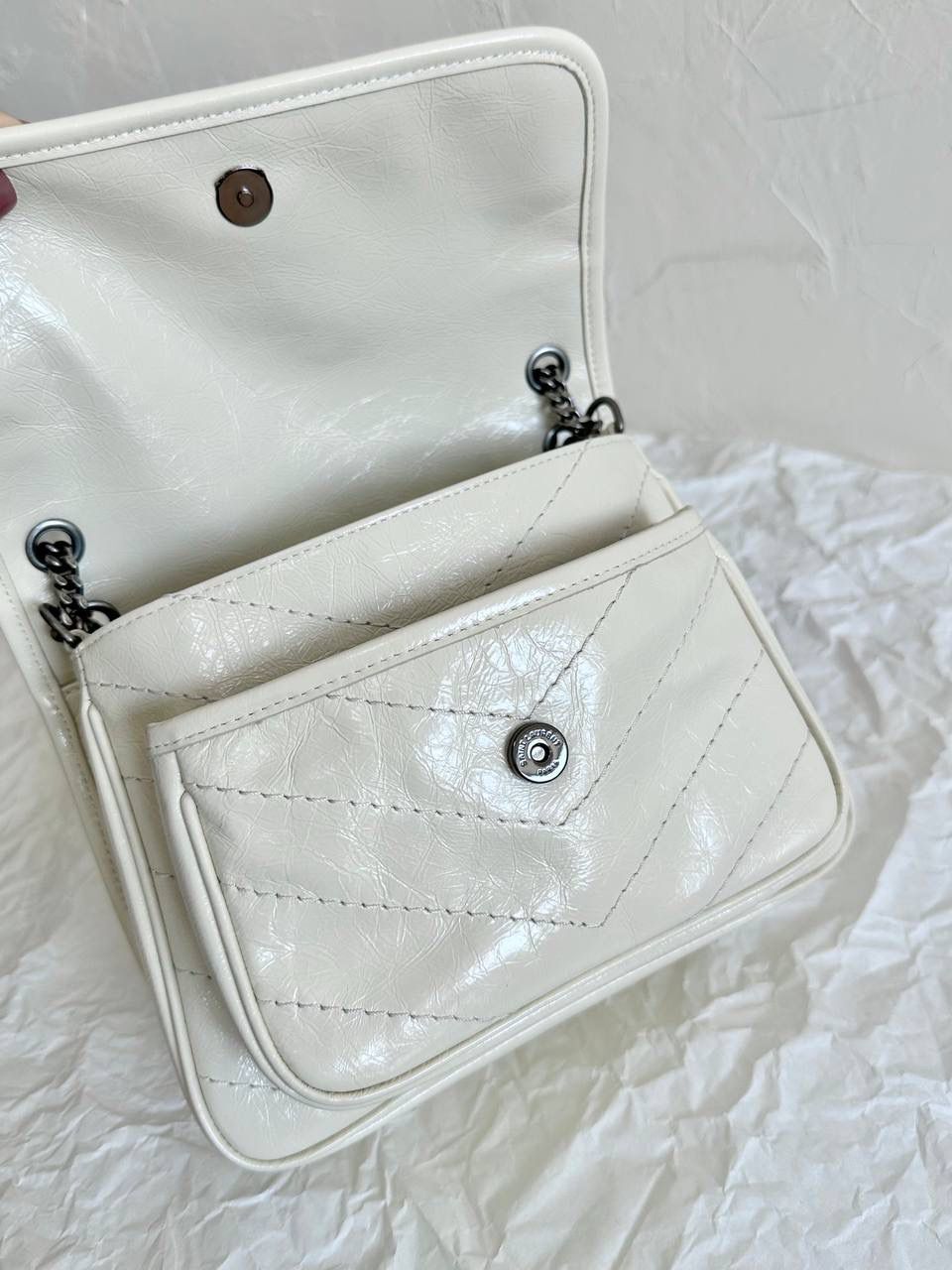 ys1 niki 油蜡皮奶白色小号🤍 作为他们家的must have之一 我们找到了专门做了10余年ys1的老师傅来做 按他的话说，闭着眼睛都能做出来 原厂皮，全钢五金，半金半银的烫金logo 细节可以媲美市场上所有品质 这个包真的做得非常非常好！ 我们也和zp一样同步更新了两个"D扣"小耳朵 听我一句，niki种草了就一定要买 几乎每个买了niki的姐妹都会后悔买晚了！ 早买早享受咯～ 小号：22×16×7.5cm633160m 中号：28x20x8.5cm633158m