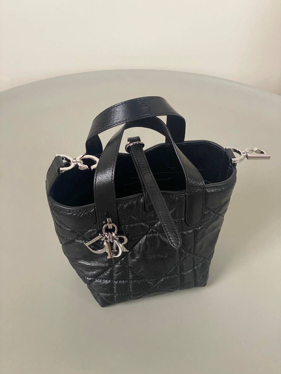 🈶油蜡黑，迷你 𝗗𝗜𝗢𝗥 𝗧𝗼𝘂𝗷𝗼𝘂𝗿𝘀新版竖款 火爆全网toujours缩小版来啦！ 看到真的心动得不行～ 实物就是常规迷你水桶大小， 真的可爱死 别说，包虽小但容量还挺大的 日常用品都能轻松装上 肩带长度也刚刚好，不挑身高 反正就是太乖啦！夏日必备 😍 13×15×12cm #M1272m