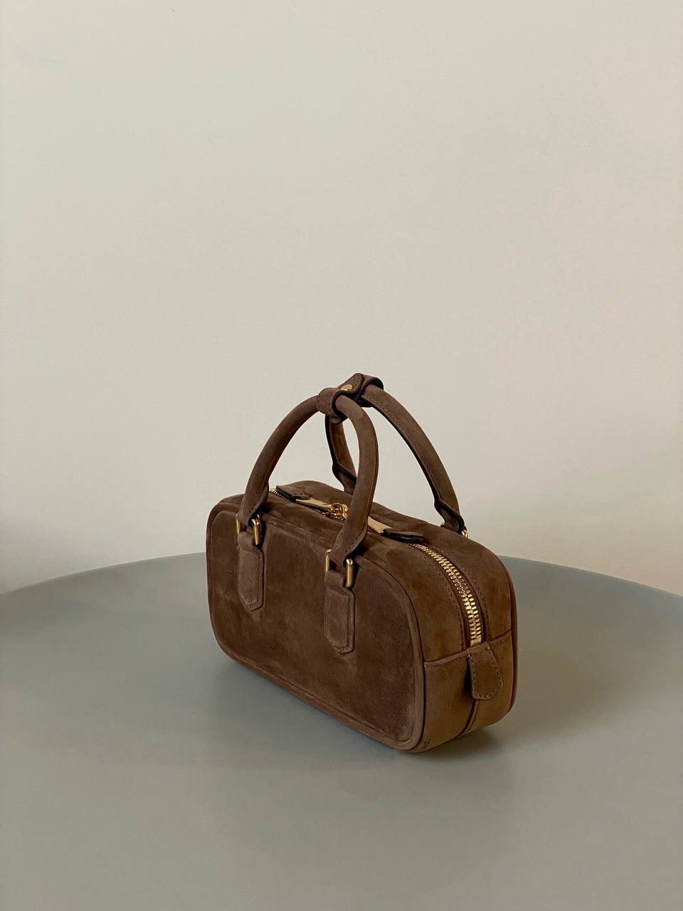 🈶可可棕，小号 𝗠𝗶𝘂𝗠𝗶𝘂24秋冬保龄球 今年棕麂皮系列大人气啊！深深的巧克力色，满满秋冬味儿～ 绒面皮每年都会有，但是！！今年这股风刮的特别猛 从秀场到ins博主穿搭，或者线上门店 几乎都有麂皮元素！ 西装款 夹克 风衣 鞋子 包括包包等 延续去年美拉德色系的颜色， 今年的颜色各种各样，有深有浅 但我唯爱咱miu家的这个巧棕色 绝对秋冬氛围感里，最“增质感”的时髦单品！ 小号：10.5×22×7.5cm #F0011m 大号：27x12x9cm