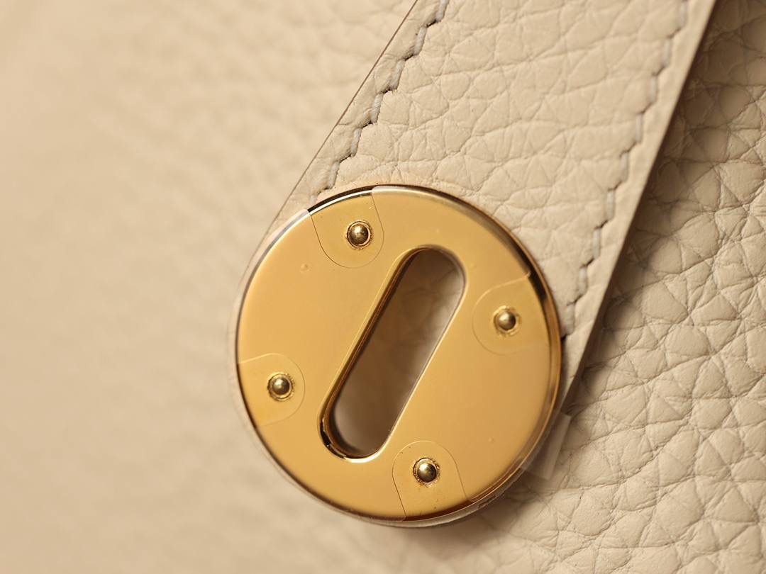 Hermes 爱马仕 Lindy 26cm 奶油白金扣👜✨ 尺寸：26*18*14 cm 奶油白真的实物很漂亮，YYDS😍 五金介绍，拉链尾部的"H"是刚好的正方形，而且每笔都是很直，菱角分明，表明平整 图二至六图的的五金四个小螺丝是人工围着这四个小圆点边雕琢上去的，而且小螺丝这点的周围圈是有孤独深的圆形，这点很多人都不知道，这个是符合正品工艺的 拉链是纯原装金扣的RIRI拉链 所以在五金方面我们拿捏的死死的 无人能敌 🤟🏻 渠道货是注重任何一个细节的 做到任何人都做不到的点 这就是天花板😍💯👍