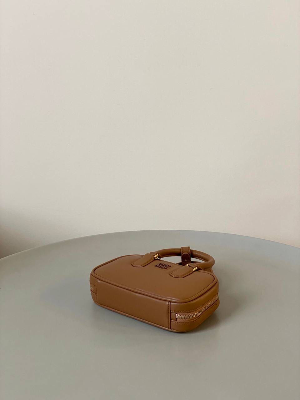 🈶干邑色，迷你 𝗠𝗶𝘂𝗠𝗶𝘂保龄球，大爆款 新尺寸也太可爱了！ 喜欢小包的姐妹这只必买！它要比小号小一些也窄一些 就巴掌大小，但容量还挺大的 装俩部手机都绰绰有余，日常够用 肩带长短也很ok，手拎斜挎都好看 反正放心冲就是了！拥有它，上班牛马的心情都会被治愈～ 迷你：19×10×5cm #F0011m 小号：22x10.5x7.5cm 大号：27x12x9cm