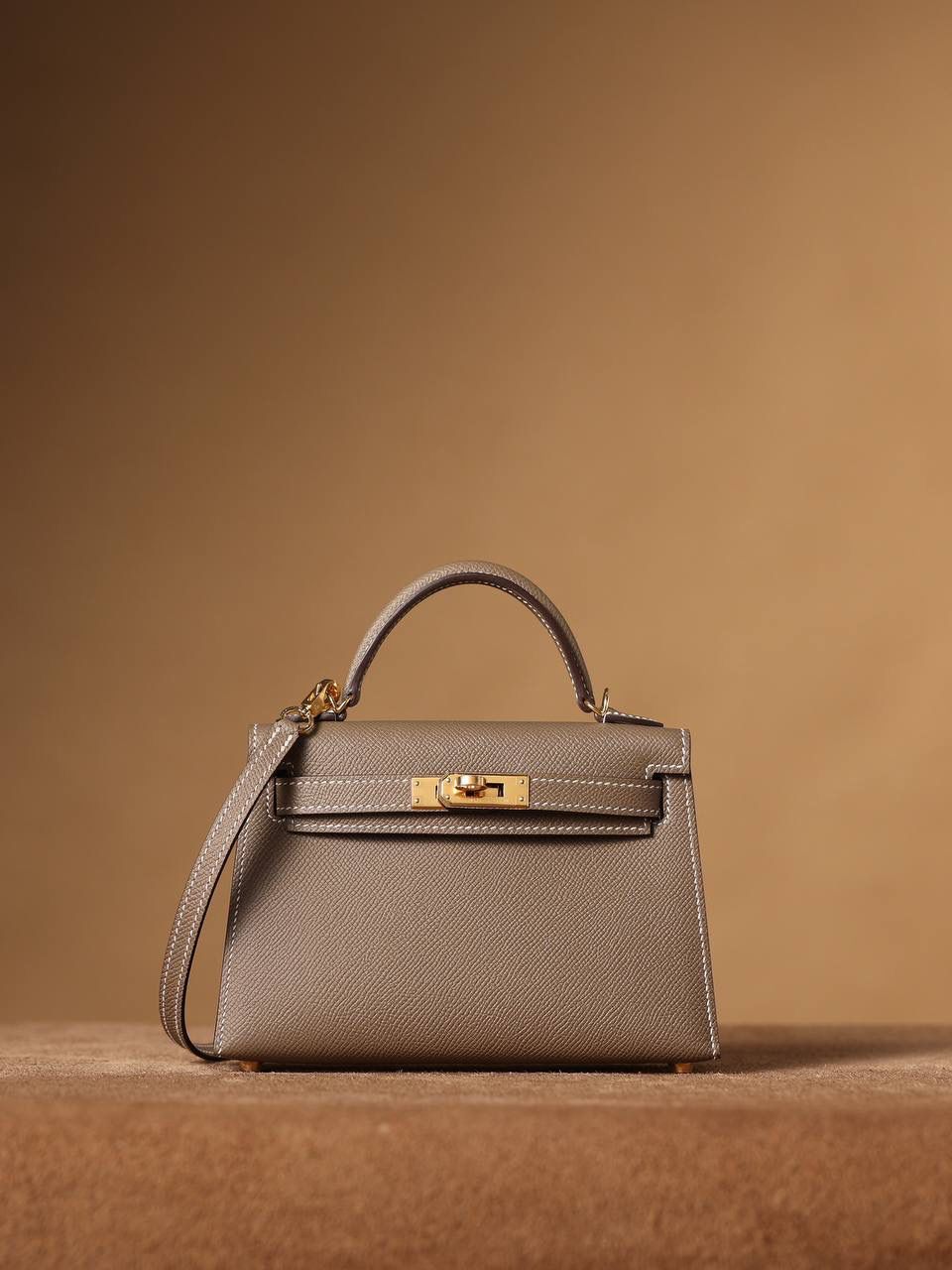 HERMES 爱马仕 Mini Kelly 二代 👜✨ Mini Kelly 二代 大象灰金扣 高清实拍图 尺寸：19*12*6cm Hermès爱马仕是世界著名的奢侈品品牌，1837年由Thierry Hermès创立于法国巴黎。爱马仕早年以制造高级马具起家，迄今已有180年的悠久历史。 其整个品牌从整体到细节以及专卖店，都弥漫着浓郁的以马文化为中心的深厚底蕴🎀