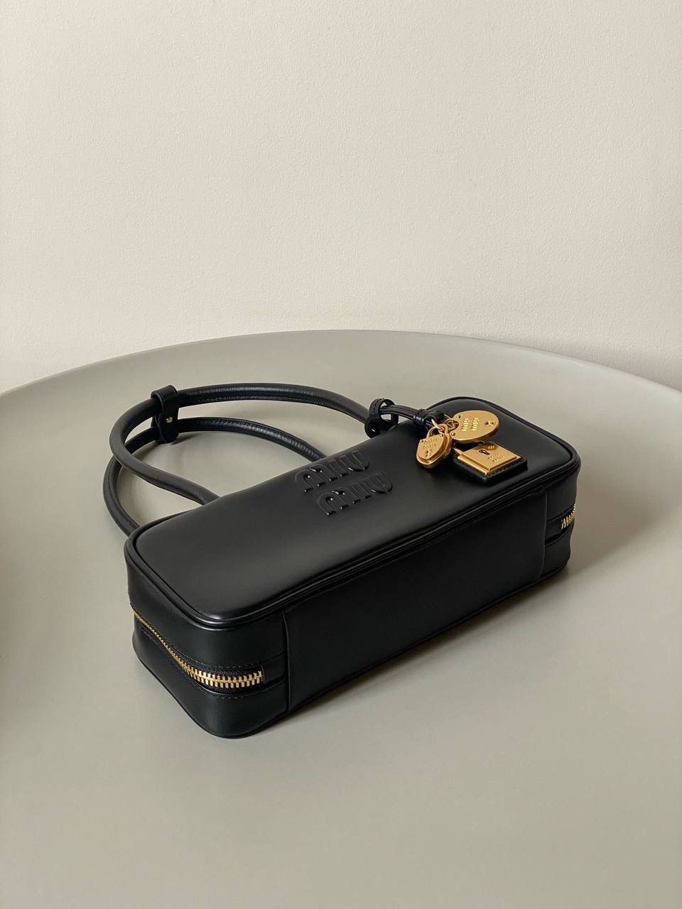 🈶黑色 𝗠𝗶𝘂𝗠𝗶𝘂保龄球| 吊饰版 说是公文包.更是保龄球！ 虽倆者都早已大火全网时髦圈哈哈 今年这只长手柄保龄球能买到就是赚到咯！ 细长的手柄整体更秀气了 还送了一串吊饰 是一把锁头还有一个爱心， 上面都有logo刻印很精致也很厚重 宝子们再也不愁买挂饰啦！ 28×11.5×8cm #F0010m