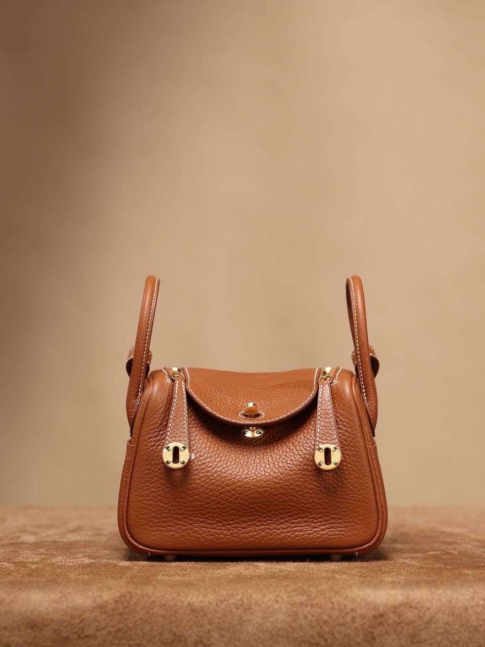 Hermes 爱马仕 Lindy Mini 19cm 金棕色金扣👜✨ Lindy 独家渠道货 独家欧洲原厂皮原厂五金组装的ZP尾单货 尺寸：19*12.5*9cm Lindy是采用原厂的正品TC皮，什么是TC皮？ 爱马仕专用的clemence,简称tc皮，是Hermes最受欢迎的皮革之一，颜色会比Togo少一些，但是纹路比Togo细腻，含油更高，更软，因此稍稍有些下垂感的特点。