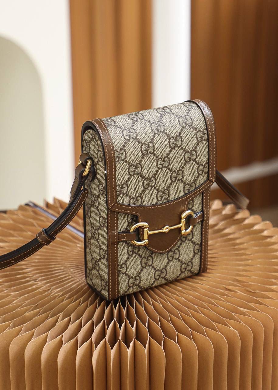 马衔扣 𝟭𝟵𝟱𝟱系列手机包 原厂皮/纯铜五金 ❤️ ☞型号：625615 尺寸：11.5*17*4cm 这款马衔扣标志的手机包，真是一见钟情，相见恨晚的知音，复古气息十足，老花本身就很百搭吸眼球，搭配复古的棕色皮料设计，大家非常喜爱的马蹄扣设计，分分钟想让人入手的冲动，可爱的造型，容纳量非常的高，日常出门的必备神器，颜值担当，不只装下可爱，男女都可共同，爱了！🤩🤟🏻