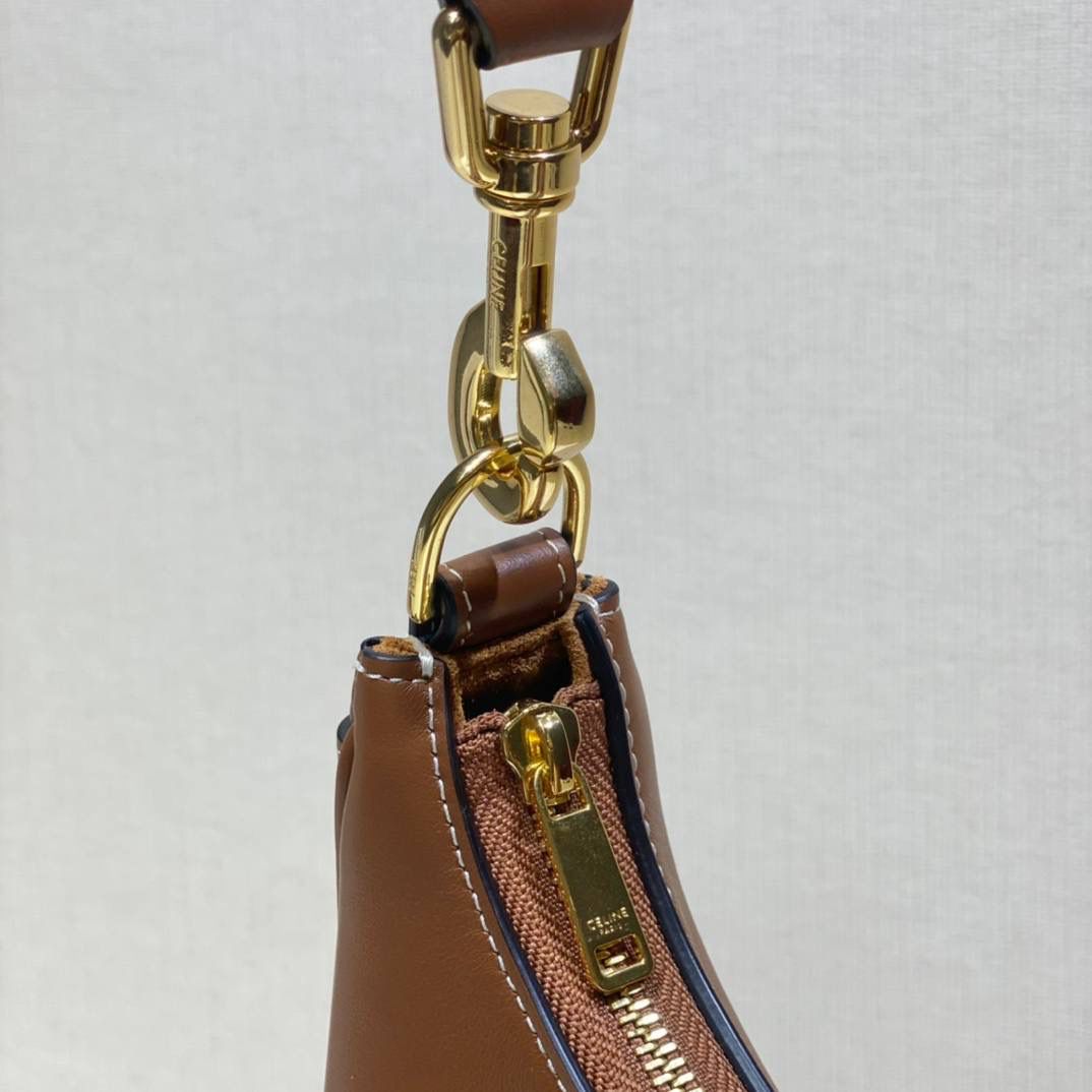 🔥大货实拍图 𝗖𝗘𝗟𝗜𝗡𝗘 ♥ 𝗔𝗩𝗔 𝗦𝗧𝗥𝗔𝗣 独特新月包型打造摩登格调，醒目金属圆环与考究皮革饰带点缀，匠心与巧思交织，定格别致意趣造型。型号：196923 尺寸：24*13*7cm