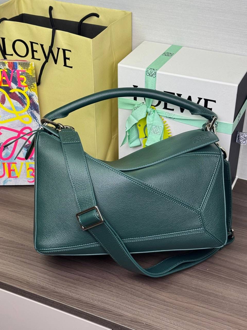 🎈【全钢】大号鹿皮𝘗𝘶𝘻𝘻𝘭𝘦* ——【👉🏻常青色到货✅】 尺寸：𝟑𝟐.𝟓-𝟏𝟒.𝟓-𝟐𝟑.𝟓𝐜𝐦 编码：260403 【配全套包装】 ❤️经典拼图系列•不规则立体几何设计•最具辨识度的立体廓形和几何美学•顶级进口皮搭配德国沙菲线•独家定制五金•𝗬𝗞𝗞拉链拉头。 ❤️该款大号采用鹿皮革制成•绒面内里•搭配一条可拆卸可调节的皮肩带•肩背斜挎或手提多样化背法。