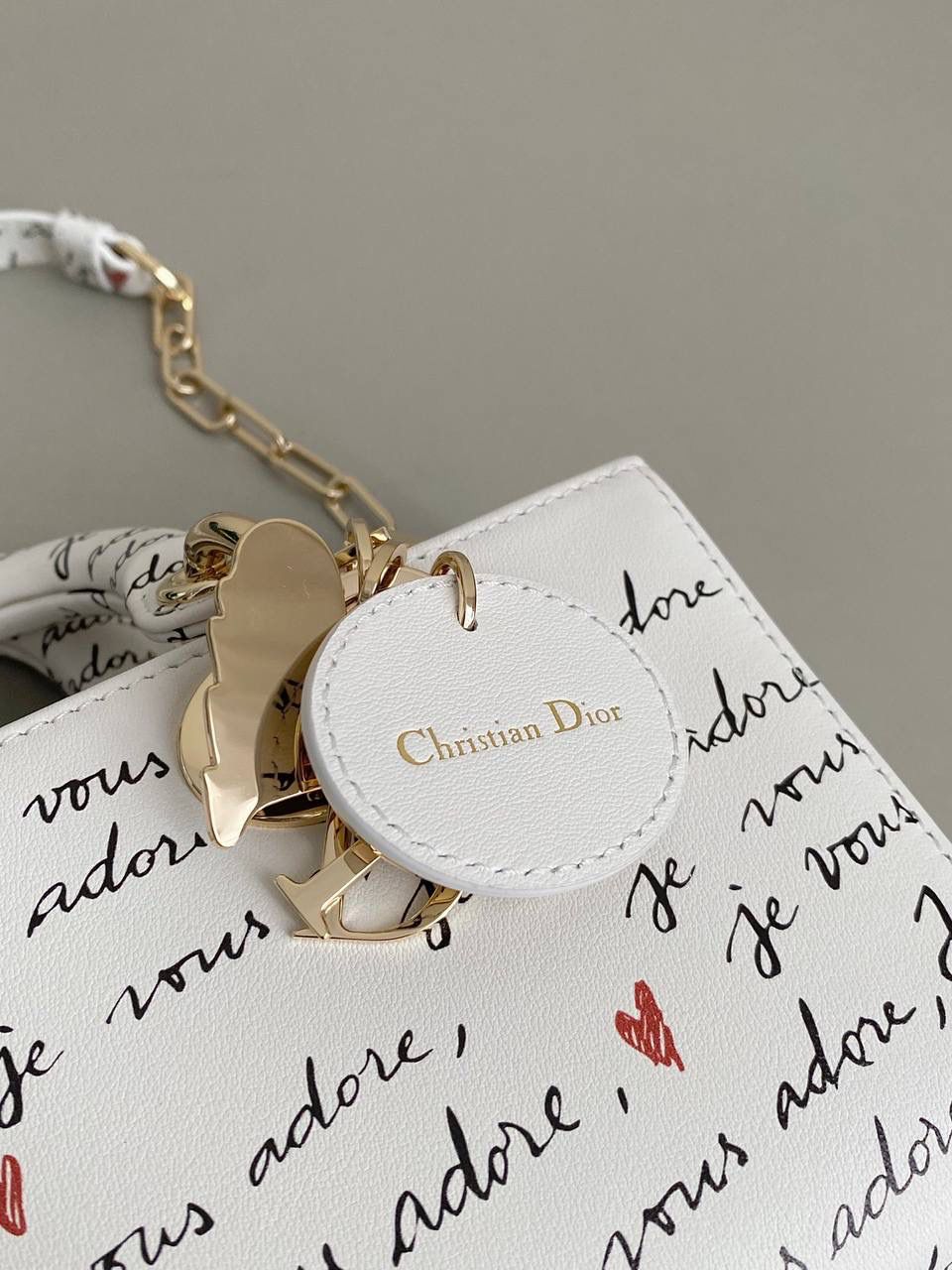 爱心白🎀𝗗𝗜𝗢𝗥 𝗗-𝗝𝗼𝘆小号 七夕限定，更是每一天的爱意限定 情书💌款这种淡淡的色调好梦幻 从印花到纯色都散发着治愈的气息 刻印的纹理感，伸手可触 连绵不断的法语我爱你'点缀着爱心❤️ 是写满了法式浪漫的包包呀！ 请拥有，这独一份的爱意 22×12×6cm