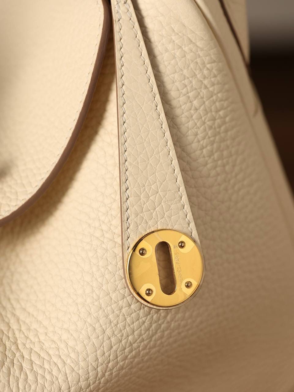 Hermes 爱马仕 Lindy 26cm 奶油白金扣👜✨ 尺寸：26*18*14 cm 奶油白真的实物很漂亮，YYDS😍 五金介绍，拉链尾部的"H"是刚好的正方形，而且每笔都是很直，菱角分明，表明平整 图二至六图的的五金四个小螺丝是人工围着这四个小圆点边雕琢上去的，而且小螺丝这点的周围圈是有孤独深的圆形，这点很多人都不知道，这个是符合正品工艺的 拉链是纯原装金扣的RIRI拉链 所以在五金方面我们拿捏的死死的 无人能敌 🤟🏻 渠道货是注重任何一个细节的 做到任何人都做不到的点 这就是天花板😍💯👍