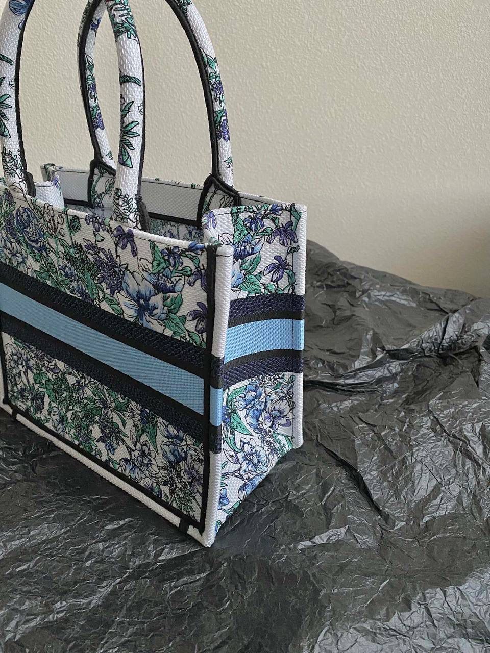 🈶蓝白花卉，小号 𝗖𝗗 𝗕𝗼𝗼𝗸 𝗧𝗼𝘁𝗲 23最新购物袋 白色底，蓝色与紫色映衬的花卉和绿叶 几分漫而梦幻的氛围气息，清新活力 给人一种愉悦，治愈，纯净美好的感觉✨🏖️ 温柔又自由的蓝，不急不躁的态度很微妙 拨动心弦的花卉世界，一定不要错过！ 26.5×21×14cm
