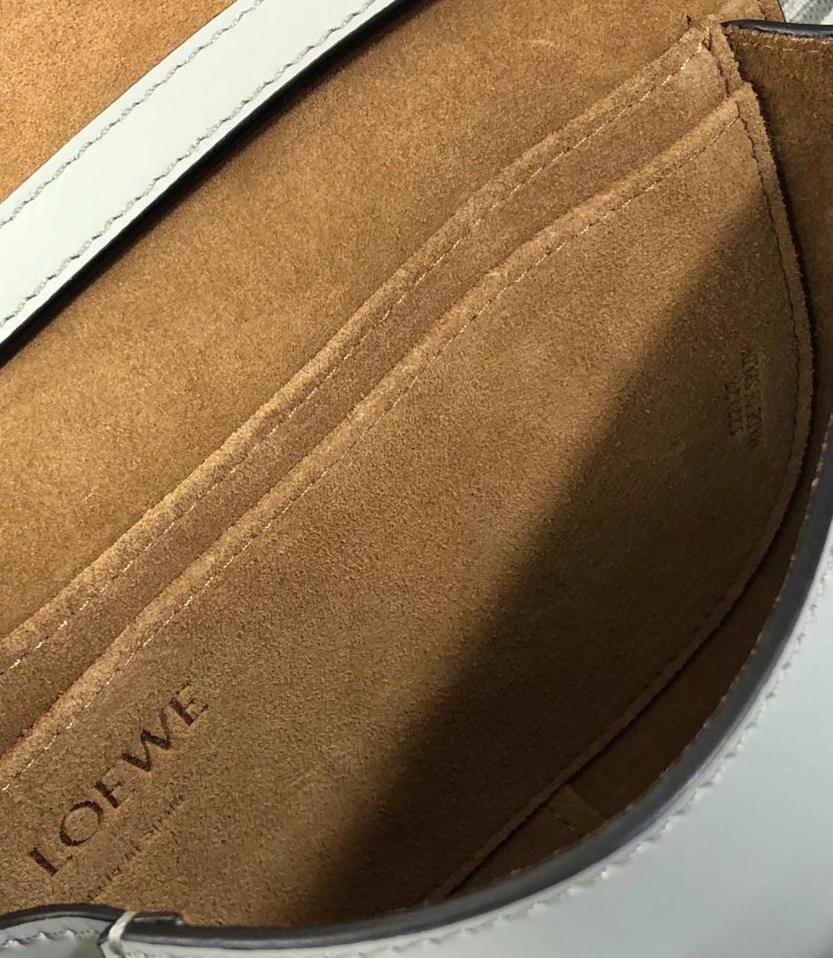 长在了中国人的审美上——罗威 精简低调的包款，设计也非常独特，采用天然牛皮革精制而成，并配有马鞍缝线的打结皮革带和侧面锁扣的金属插鞘，该系列包袋由此而得名。 迷你:15-9.5-12.5（中部最宽处21cm） 编码:522127织带粉末灰