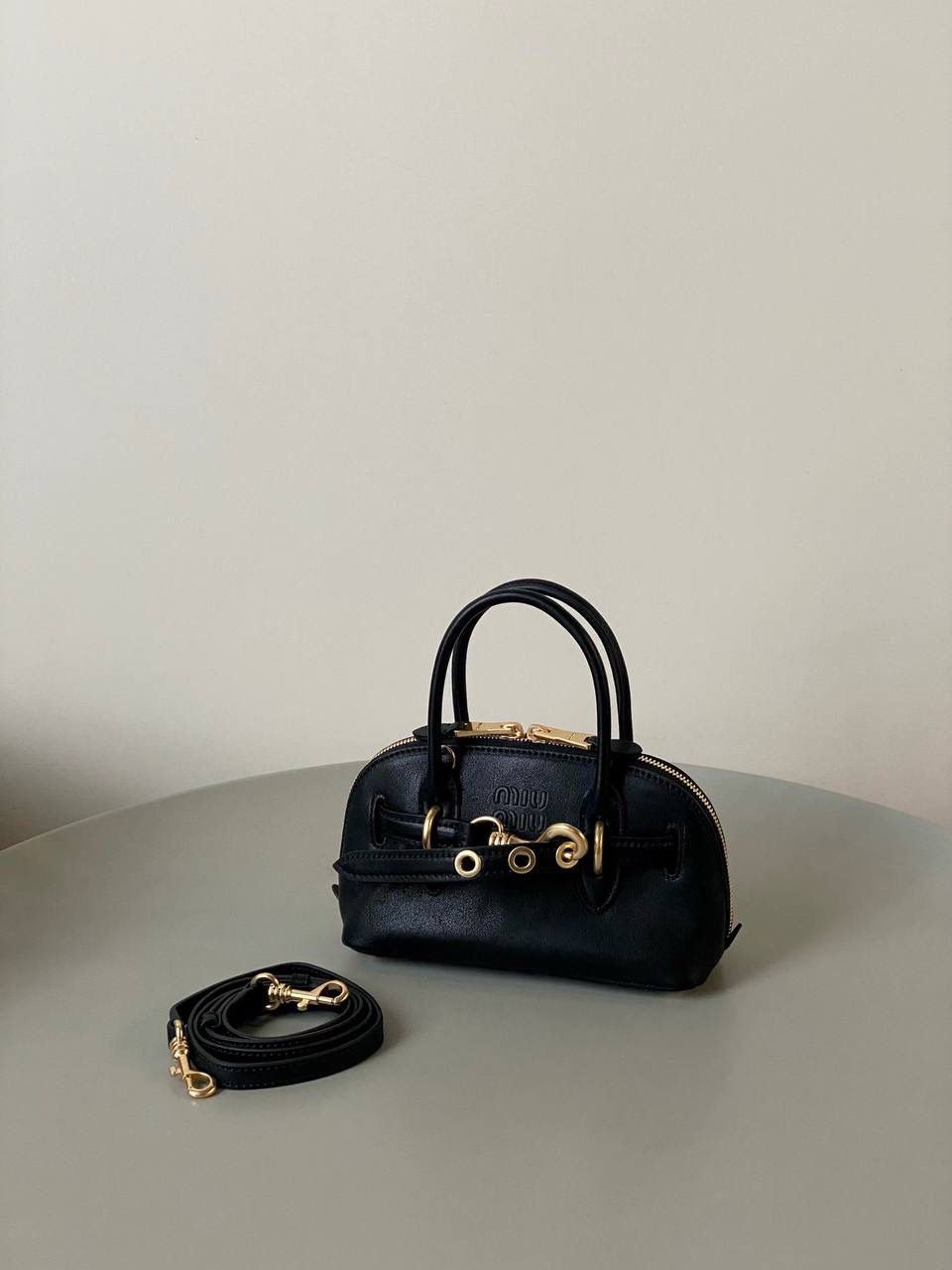 🈶黑色，迷你 𝗠𝗶𝘂𝗠𝗶𝘂24秋冬贝壳包 年度爆炸款来啦 | 真心被夸爆 没有过分夸张的设计，有着时髦且个性的圆弧包型，形似贝壳，看着很轻松又舒适一点也不会给人压力 双向拉链在保证实用性的同时让它充满了复古的调性，搭配上腰带式设计细节，时髦有态度 面料手感软糯，拎在手上可以切确感受到高级质感 迷你：8×13×21cm #F0022m 小号：16.5x28x10cm 大号：33x17x11cm