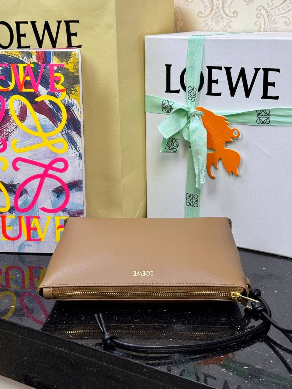 🎈𝘒𝘯𝘰𝘵 𝘛手拿包👜 —【橡木棕/黑色到货✅】 编码：522414 尺寸：𝟐𝟐.𝟓-𝟓.𝟓-𝟏𝟓.𝟓𝐜𝐦 全新撞色绳结拉链头和腕带设计，顶部拉链开合，内部人字纹帆布衬里以及2个皮隔层卡位，正面饰以品牌标志性烫金𝗟𝗼𝗴𝗼，方便时尚多用。