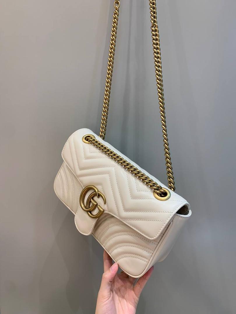 新背景实拍正品级 。经典款金扣白色26cm‼️ 黑色销量第一的话那白色绝对稳居榜单第二、夏天超级热卖，基本人手一个，奶白奶白的颜色，简单干净舒服，皮质五金都是最好级别的，恰到好处的复古调调，很有质感‼️ 型号443497；尺寸26/15/7cm