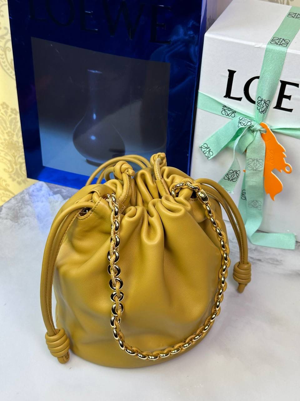 🎈链条款𝙁𝙡𝙖𝙢𝙚𝙣𝙘𝙤 𝙋𝙪𝙧𝙨𝙚水桶羊皮 ——【沙漠黄】 尺寸：𝟑𝟐-𝟏𝟕-𝟐𝟒𝐜𝐦 编码：062406 👉🏻延续福袋收缩绳褶皱设计，全新推出水桶造型，羊皮包身手感细腻柔软❤️ 👉🏻链条肩带➕皮肩带的双肩带设计，时尚百搭，给足了集美们多样化的选择。肩带可拆卸可调节，磁扣开合，正面烫金𝙇𝙤𝙜𝙤，呈现出高贵典雅的视觉感😍 👉🏻独家背景➕独家品质➕独家全套砖柜礼盒套装，市场高端品质皆在我手✌🏻