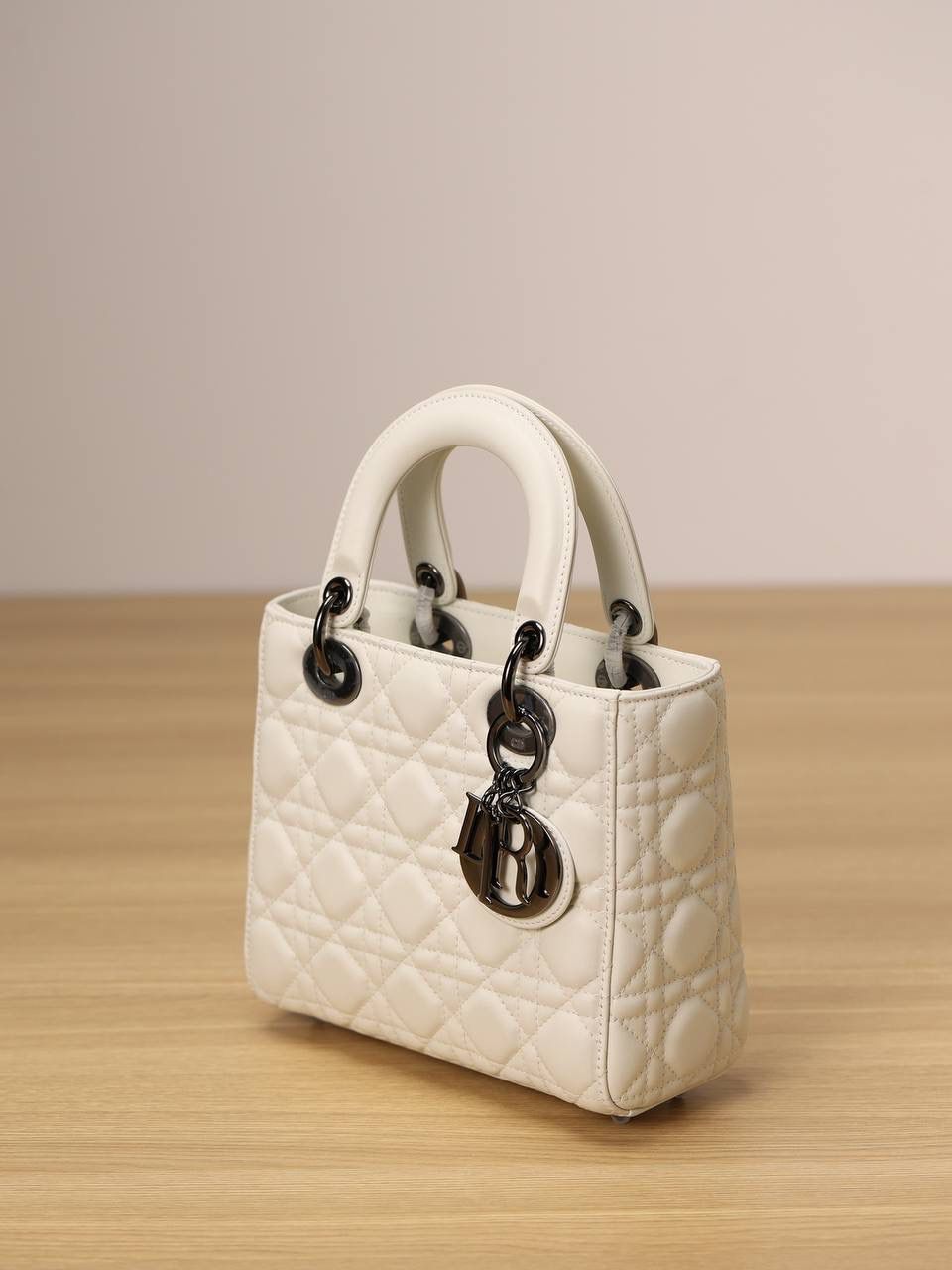 小号 LADY DIOR MY ABCDIOR 手袋 奶白色羊皮革藤格纹 独家渠道货 四格戴妃包白色羊皮枪扣 尺寸：20 x 17 x 8 厘米 这款 Lady Dior My ABCDior 手袋彰显 Dior 经典标识。 款式时尚精致，是一款经久不衰的单品。 采用奶白色羊皮革精心制作，搭配藤格纹缉面线，精良的绗缝质感显露无遗。 饰以金属覆层D.I.O.R.吊饰，为醒目的轮廓增添一分灵动💕💕