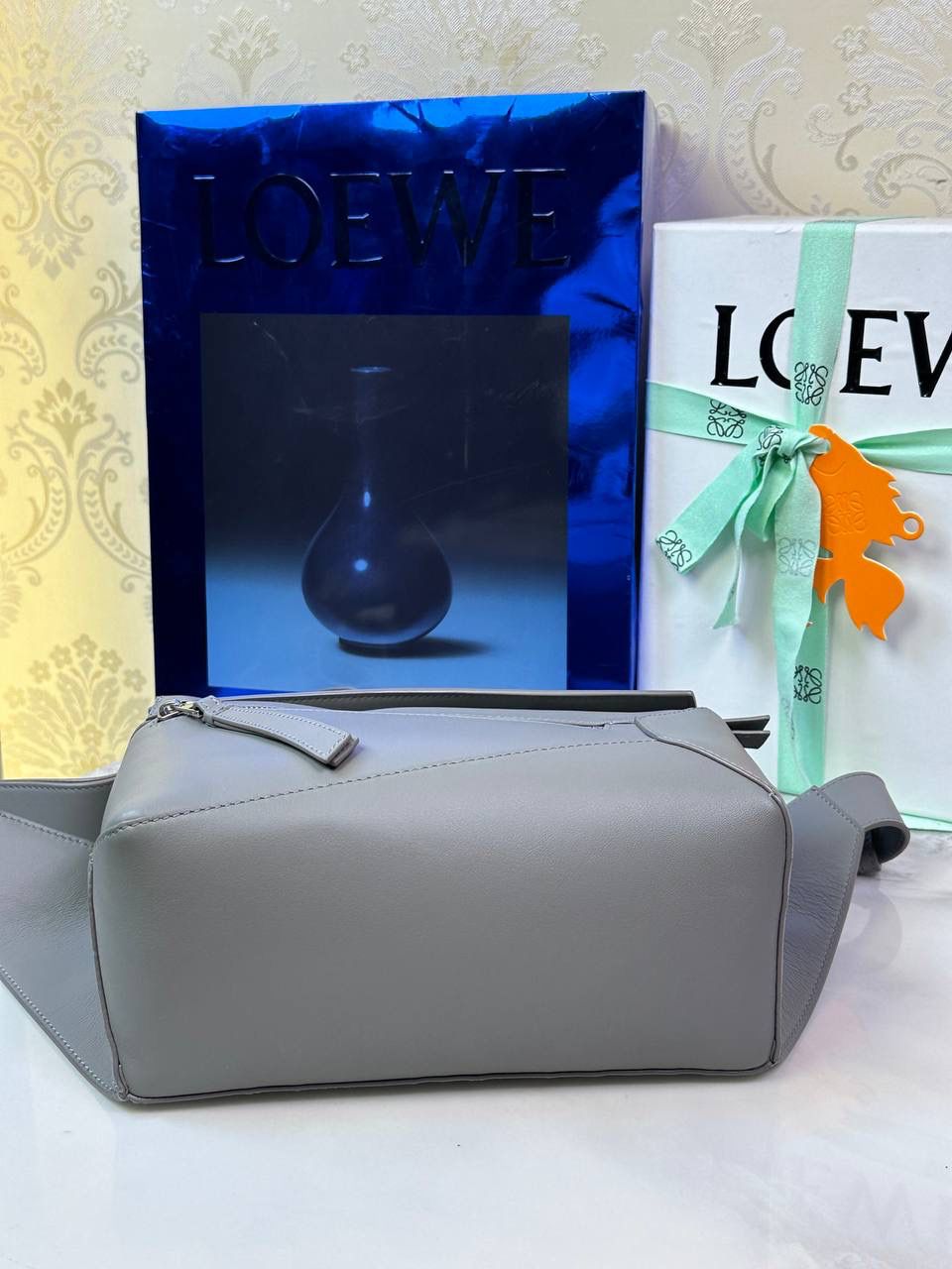 ⭐️最新升级版𝟮.𝟬-𝗣𝘂𝘇𝘇𝗹𝗲腰包⭐️ （珍珠灰到货‼️） 尺寸：𝟮𝟰-𝟭𝟬.𝟱-𝟭𝟲𝗰𝗺 款号：052343 👉🏻长方体形状和精确的切割技巧创造出Puzzle 腰包以及独特的几何线条成为 “Loe罗家”的著名代表作~ 👉🏻金属搭扣开合，刻有标志logo徽标，可调节肩带，翻盖大容量插袋和一个外部拉链口袋，🐂柔软细腻napa小牛皮，正品Ykk五金，Anagram压纹，人字纹棉麻帆布内里 👉🏻（男女♀♂同款）大小非常合适。胸包、背包、单肩、斜挎、腰包五种背法任你解锁🔒 👉🏻 （独家背景➕独家品质➕独家包装➕独家控制对版细节📦➕精致全套礼盒套装❤️） 重点：让你花最少的钱💰体验最大的仪式感❤️