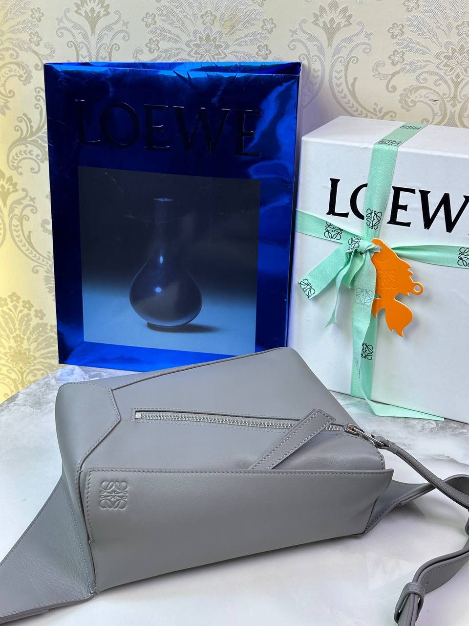 ⭐️最新升级版𝟮.𝟬-𝗣𝘂𝘇𝘇𝗹𝗲腰包⭐️ （珍珠灰到货‼️） 尺寸：𝟮𝟰-𝟭𝟬.𝟱-𝟭𝟲𝗰𝗺 款号：052343 👉🏻长方体形状和精确的切割技巧创造出Puzzle 腰包以及独特的几何线条成为 “Loe罗家”的著名代表作~ 👉🏻金属搭扣开合，刻有标志logo徽标，可调节肩带，翻盖大容量插袋和一个外部拉链口袋，🐂柔软细腻napa小牛皮，正品Ykk五金，Anagram压纹，人字纹棉麻帆布内里 👉🏻（男女♀♂同款）大小非常合适。胸包、背包、单肩、斜挎、腰包五种背法任你解锁🔒 👉🏻 （独家背景➕独家品质➕独家包装➕独家控制对版细节📦➕精致全套礼盒套装❤️） 重点：让你花最少的钱💰体验最大的仪式感❤️