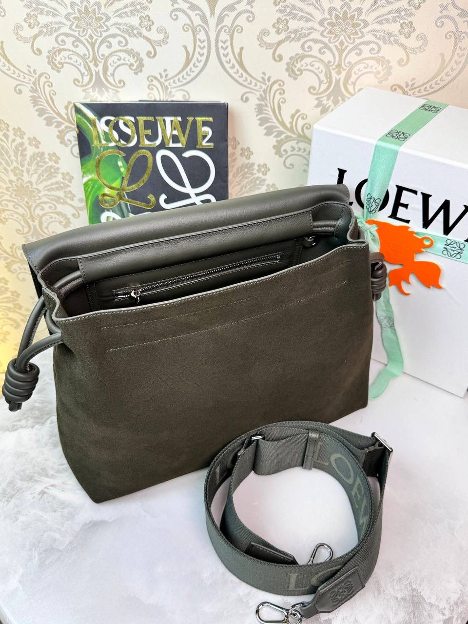 𝙇𝙤𝙚𝙬𝙚 𝙁𝙡𝙖𝙢𝙚𝙣𝙘𝙤 𝙎𝙖𝙩𝙘𝙝𝙚𝙡 福袋款邮差包 ➕刺绣🅾️字母宽肩带 编码：062404 尺寸：𝟑𝟒-𝟏𝟐-𝟐𝟒𝐜𝐦 新款以经典福袋收缩打结为元素，采用外部麂皮➕内里𝗡𝗮𝗽𝗮小牛皮➕刺绣字母宽肩带的精致搭配打造全新升级款邮差包🅰️，可斜挎、肩背和手提，超大容量满足日常所需🎈