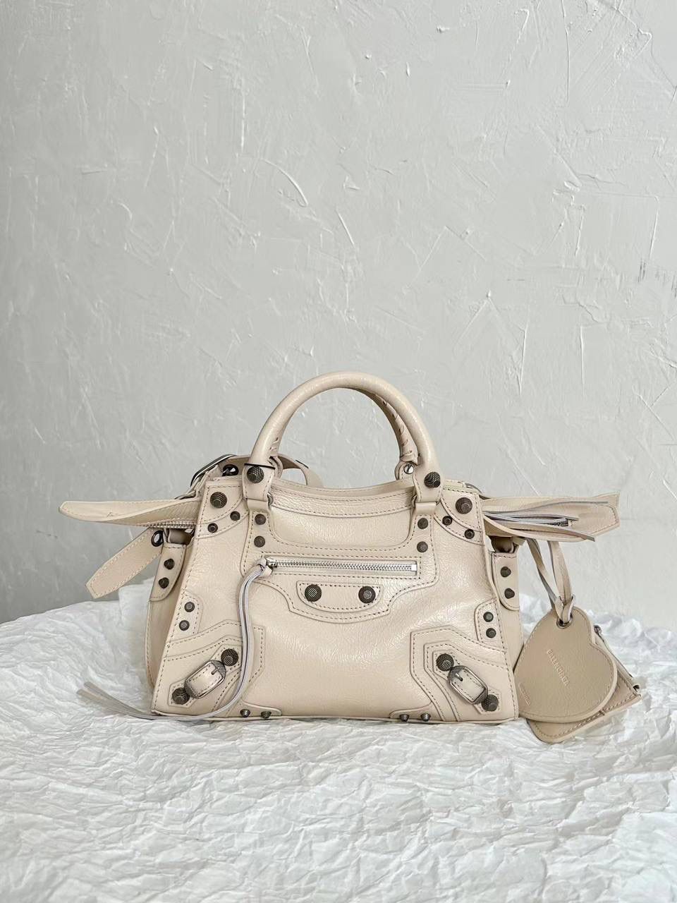 销量王🔥 Neo classic 机车包xs 首先声明，我爱一切机车元素 无论是le cagole还是这只neo 喜欢大容量的姐妹冲这只 油蜡皮的不规则摔纹配上大量的五金配件 还有流苏拉牌➕爱心镜子➕零钱包挂件 极繁的魅力由此而来～ 辣妹酷妹冲冲！ 26×17.8×11.4cm700940m