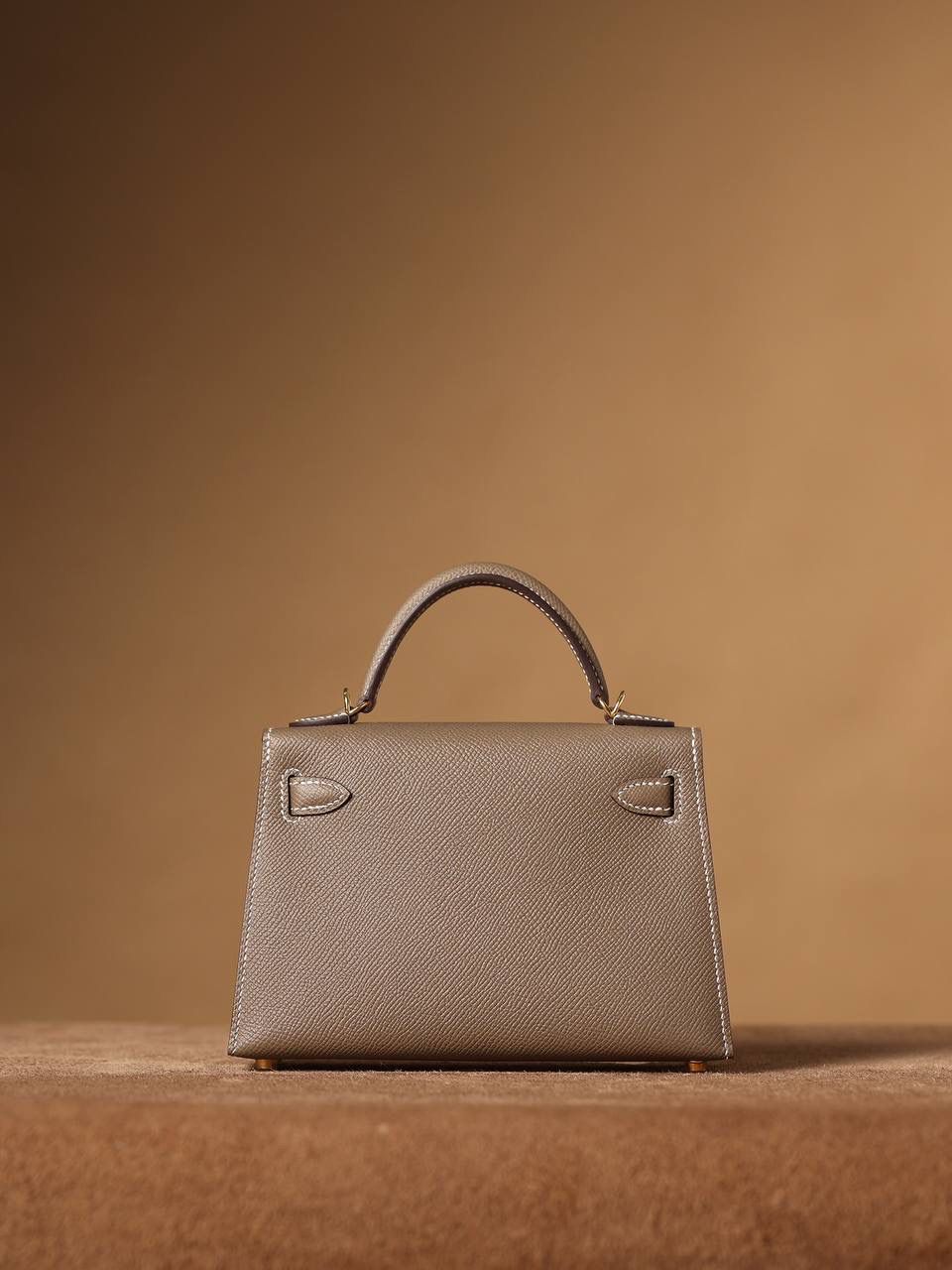 HERMES 爱马仕 Mini Kelly 二代 👜✨ Mini Kelly 二代 大象灰金扣 高清实拍图 尺寸：19*12*6cm Hermès爱马仕是世界著名的奢侈品品牌，1837年由Thierry Hermès创立于法国巴黎。爱马仕早年以制造高级马具起家，迄今已有180年的悠久历史。 其整个品牌从整体到细节以及专卖店，都弥漫着浓郁的以马文化为中心的深厚底蕴🎀