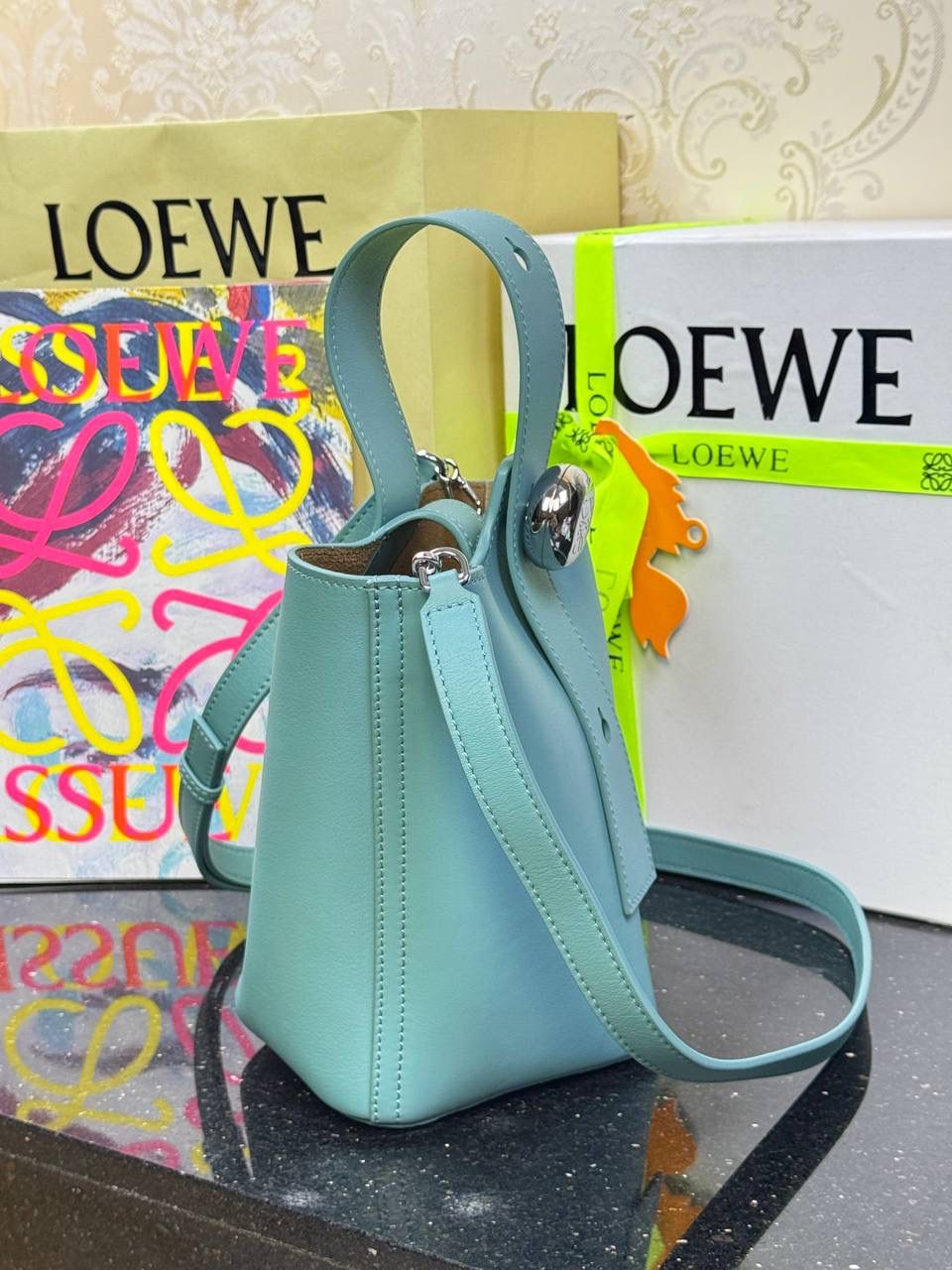 ♥️𝙈𝙞𝙣𝙞 𝙋𝙚𝙗𝙗𝙡𝙚 𝘽𝙪𝙘𝙠𝙚𝙩 ——【水蓝色】 尺寸：𝟏𝟔-𝟏𝟔-𝟗.𝟓𝐜𝐦 编码：062339 🎈标志性Anagram鹅卵石点缀，配以纯粹简约线条以及瞩目设计风格，诠释全新𝙋𝙚𝙗𝙗𝙡𝙚手袋👜 🎈自带一根🉑拆卸🉑调节的肩带，一包多背，多样化风格，秀场大放异彩😀内里容量超大，日常实用性强👌 🎈配全套专柜礼盒🎁，给你满满的仪式感👀