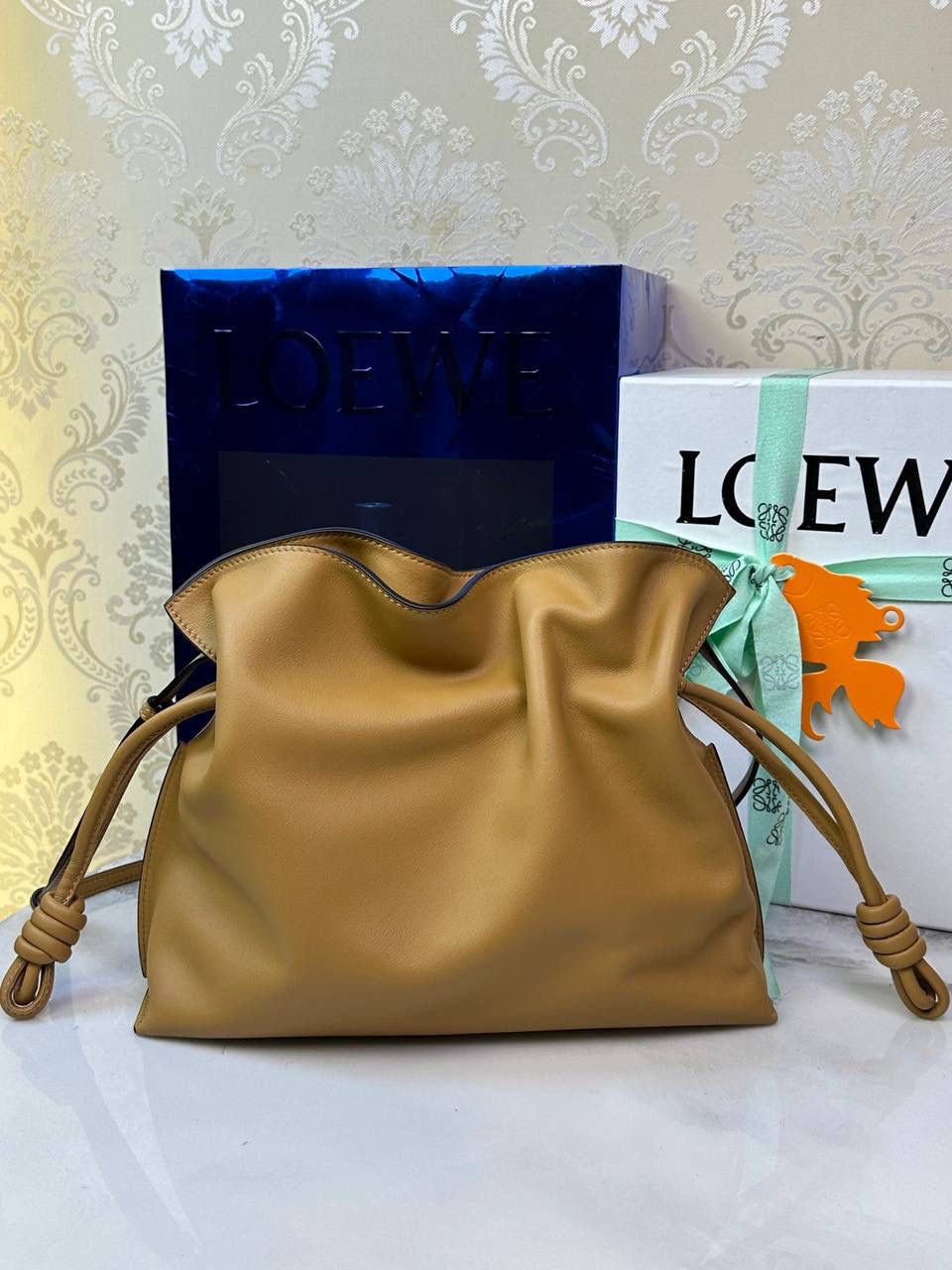 Flamenco clutch✦中号✦ 尺寸：𝟑𝟎-𝟐𝟒.𝟓-𝟏𝟎.𝟓𝐜𝐦 型号：052028 棕色 ❤️flamenco clutch bag可手拿亦可优雅斜挎 云朵般温暖亦轻盈的造型如此简单，💯耐看💯不会out的款式！ ❤️包袋采用进口小牛皮，手感如羊皮般细腻柔软，却比羊皮更加结实耐用，麂皮内衬 ❤️品牌标志性绳结设计，收紧袋口就是小福袋造型，超Q，看着不大实际超会装😇