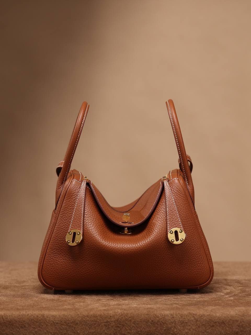 Hermes 爱马仕 Lindy 26cm 金棕金扣👜✨ Lindy 独家渠道货 独家欧洲原厂皮原厂五金组装的ZP尾单货 尺寸：26*18*14 cm Lindy是采用原厂的正品TC皮，什么是TC皮？ 爱马仕专用的clemence,简称tc皮，是Hermes最受欢迎的皮革之一，颜色会比Togo少一些，但是纹路比Togo细腻，含油更高，更软，因此稍稍有些下垂感的特点。 欣赏独家货源的美 闭眼入😍🤭🤟🏻