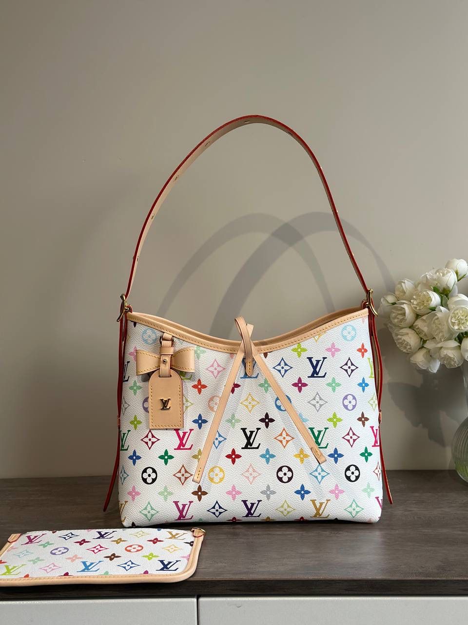 LV 白三彩 Carryall 👜✨ 这是那种—— 一背上街，别人会多看你两眼的包 🌈 白底三彩像把颜色撒进 Monogram 里， 樱花、熊猫跳出来那一刻， 整个包都在发光 ☀️ 不是甜腻，是很有态度的可爱。 Carryall BB 包型软软的、容量却很能装， 通勤不无聊，出游更加分。 蝴蝶结、链条点缀得刚刚好， 甜酷之间拿捏得很准。 如果你已经看腻普通老花， 那这只，就是春天给你的答案 🌸 📏 25 × 31 × 14 cm