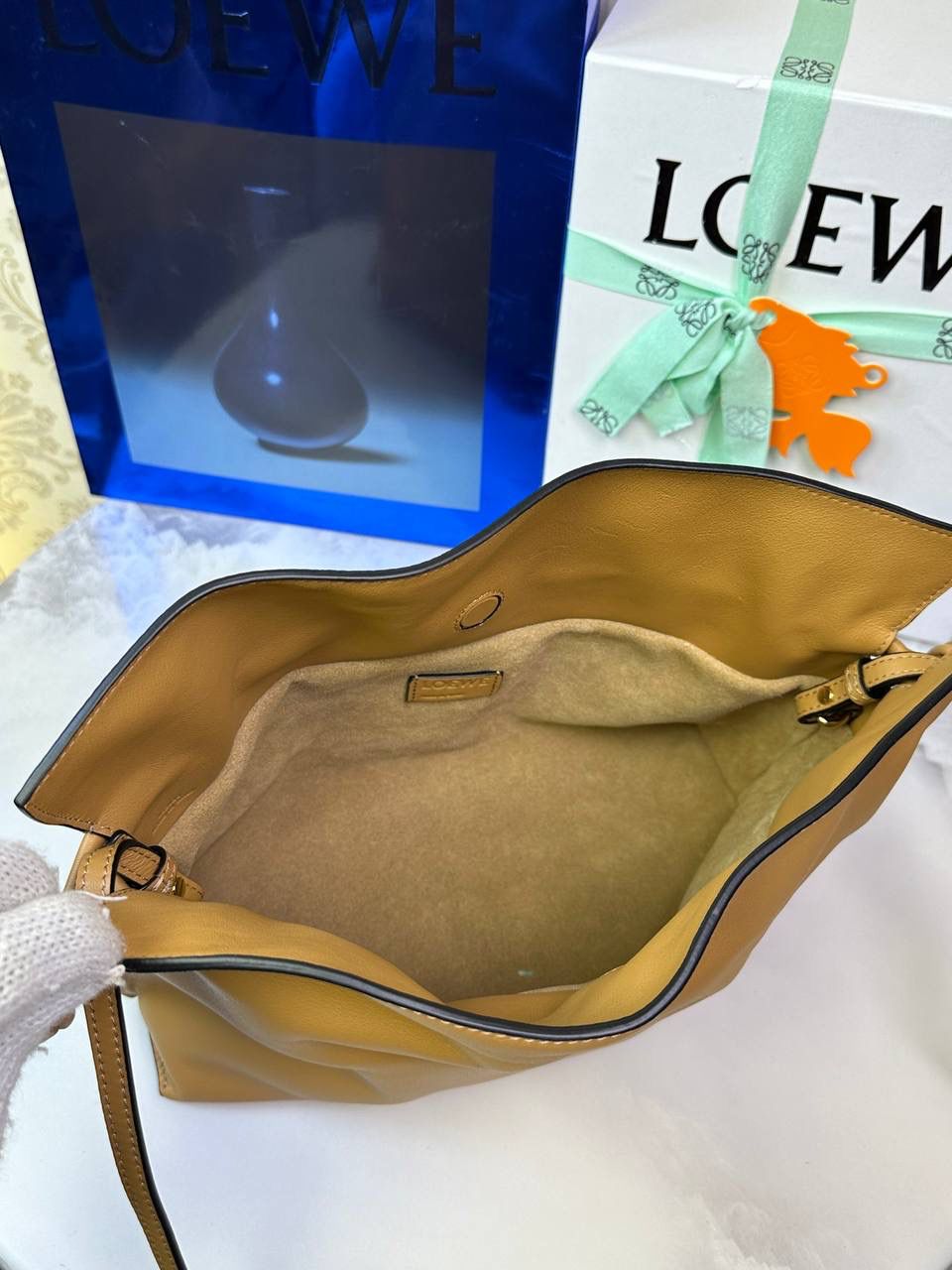 Flamenco clutch✦中号✦ 尺寸：𝟑𝟎-𝟐𝟒.𝟓-𝟏𝟎.𝟓𝐜𝐦 型号：052028 棕色 ❤️flamenco clutch bag可手拿亦可优雅斜挎 云朵般温暖亦轻盈的造型如此简单，💯耐看💯不会out的款式！ ❤️包袋采用进口小牛皮，手感如羊皮般细腻柔软，却比羊皮更加结实耐用，麂皮内衬 ❤️品牌标志性绳结设计，收紧袋口就是小福袋造型，超Q，看着不大实际超会装😇