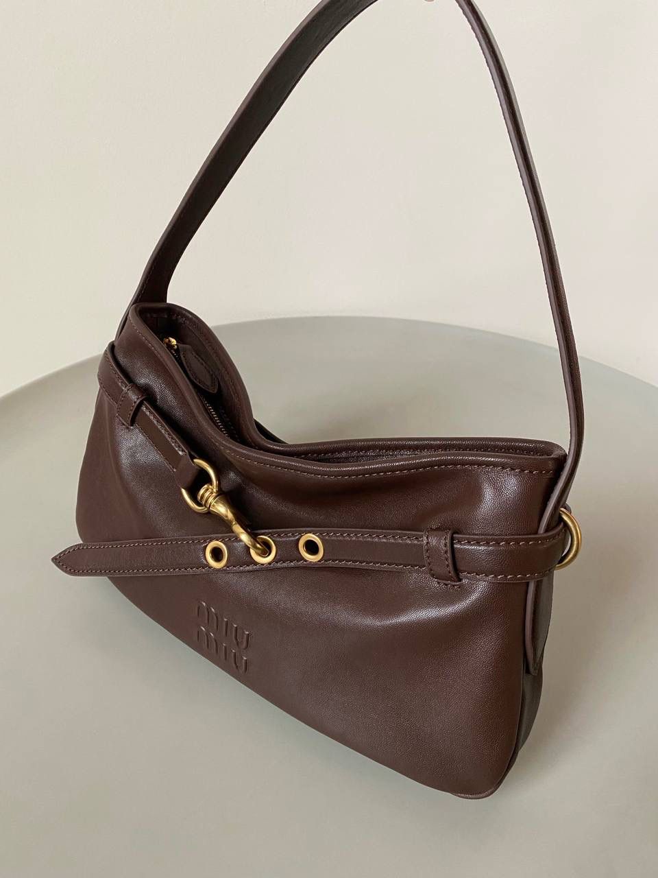 🈶石楠木色，小号 𝐌𝐢𝐮𝐌𝐢𝐮 𝐀𝐯𝐞𝐧𝐭𝐮𝐫𝐞腋下包 不得不说缪缪的美丽层出不穷！今年这只Aventure Nappa腋下包 看似平平无奇上身却意外好搭耐看 有点小复古又有点小机车， 就很值得夸赞一番 东西不用装太满，随性的褶皱感很戳心巴 自重非常轻，宽肩带设计一点都不溜肩容量空间也不错，日常东西都放的下 迷你iPai都👌🏻尊嘟人见人爱不带吹的！ 33×19×5cm #F0021m