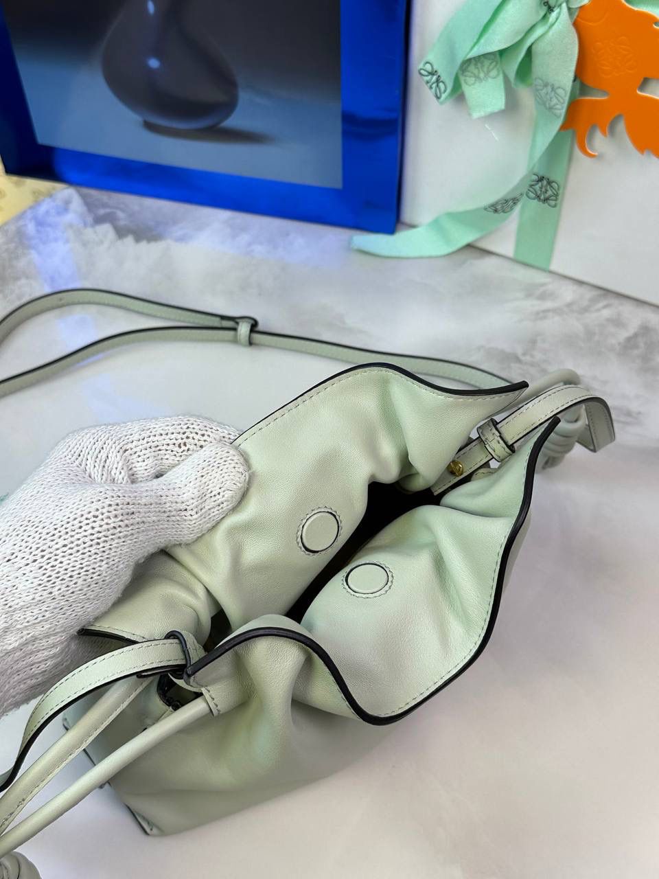 Flamenco clutch-NEW ✦迷你✦ 尺寸：𝟐𝟐.𝟓-𝟏𝟖-𝟗𝐜𝐦 型号：052030亮灰绿 ❤️mini flamenco clutch bag 可手拿亦可优雅斜挎 云朵般温暖亦轻盈的造型如此简单，💯耐看💯不会out的款式！ ❤️包袋采用进口小牛皮，手感如羊皮般细腻柔软，却比羊皮更加结实耐用，麂皮内衬 ❤️品牌标志性绳结设计，收紧袋口就是小福袋造型，超Q，看着不大实际超会装😇